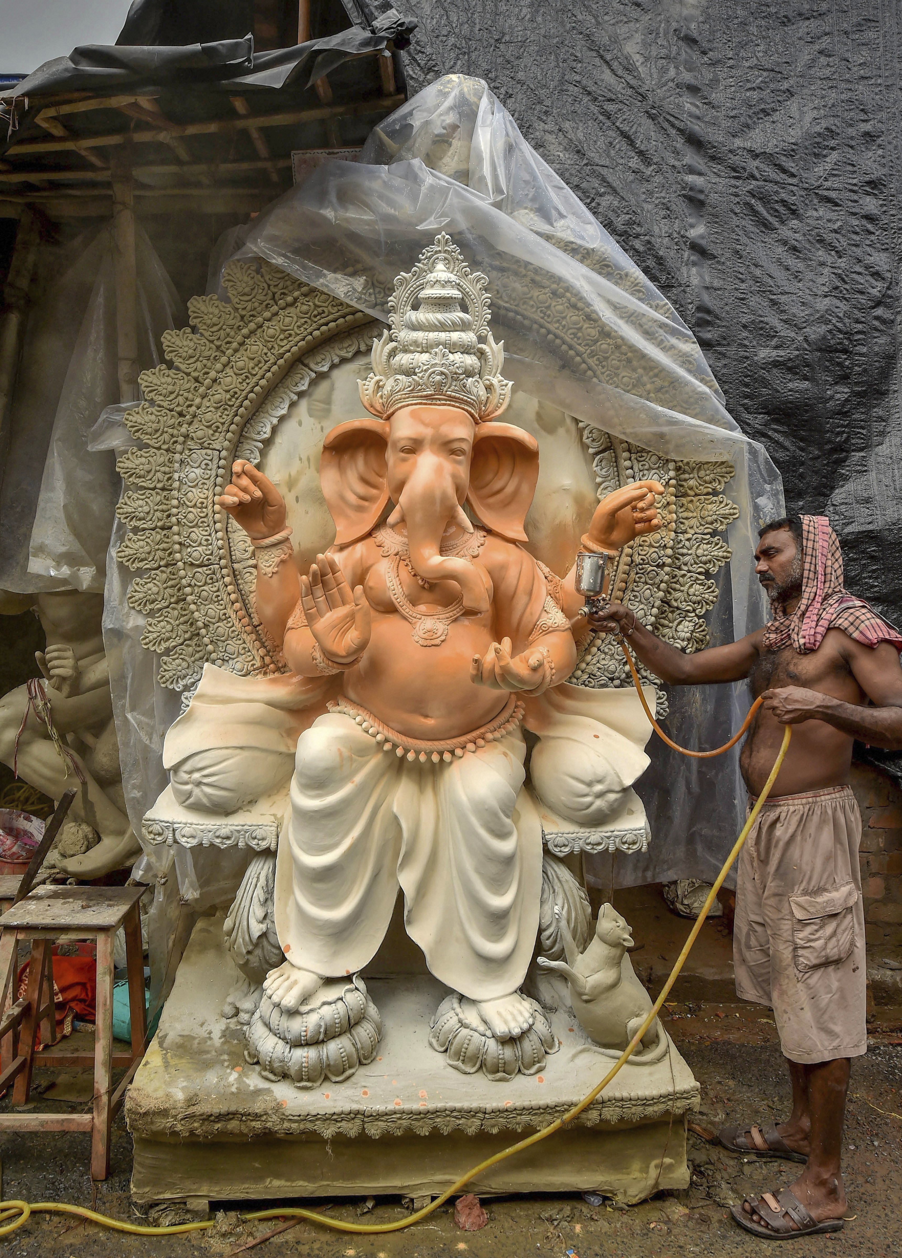 An artist paints an idol of Lord Ganesh ahead of Ganesh Chaturthi, in Kolkata - PTI