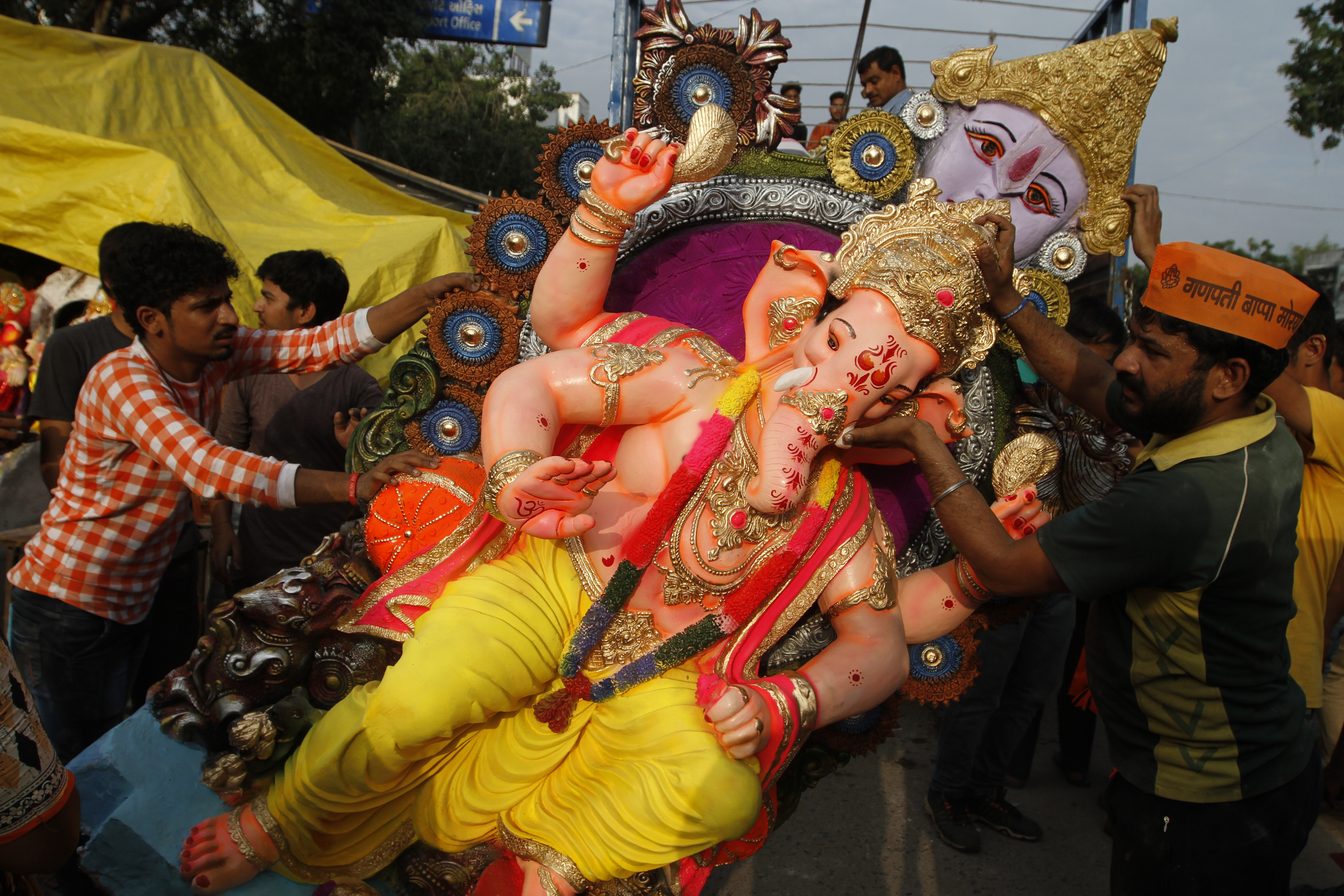 Devotees load an idol of elephant-headed Hindu God Ganesha on a vehicle on the eve of Ganesh Chaturthi festival in Ahmadabad - AP