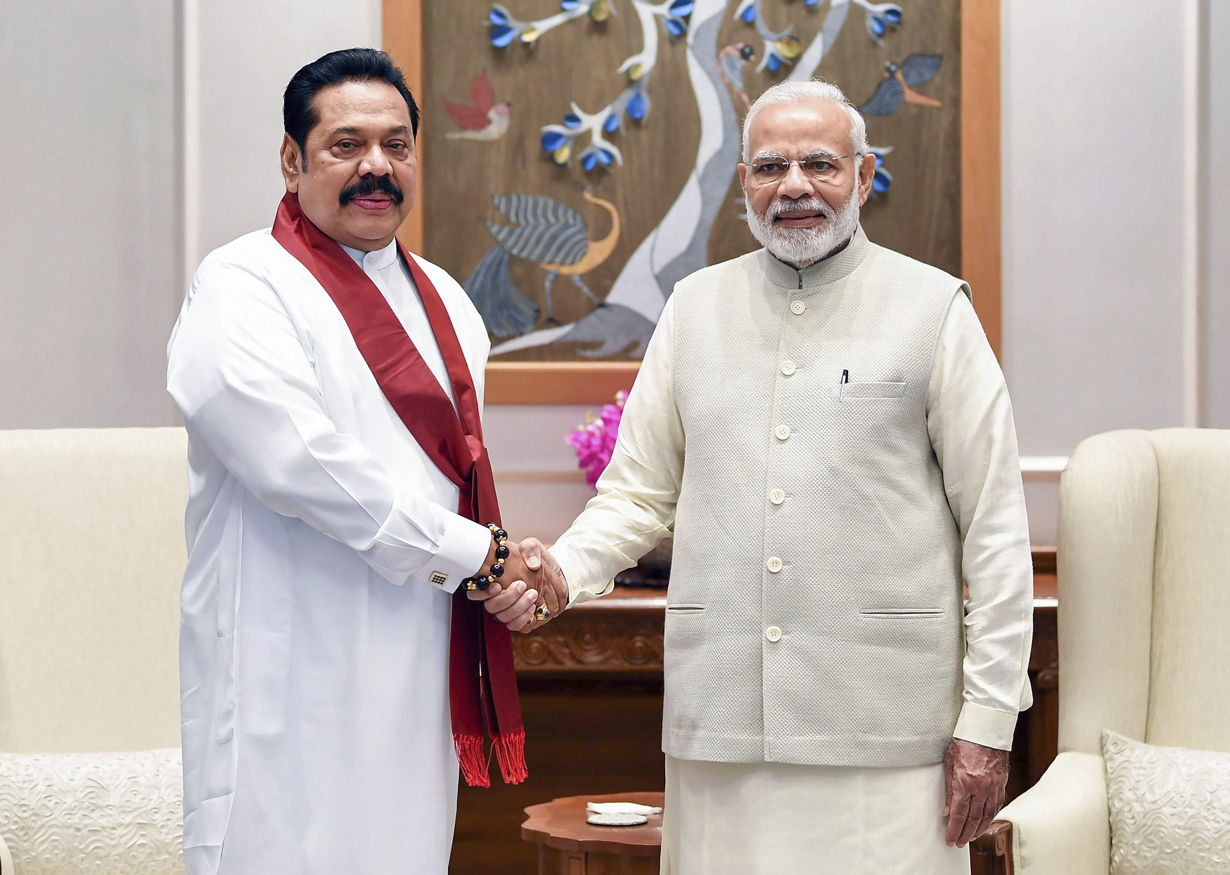 Prime Minister Narendra Modi shakes hands with former Sri Lankan president Mahinda Rajapaksa, in New Delhi - PTI