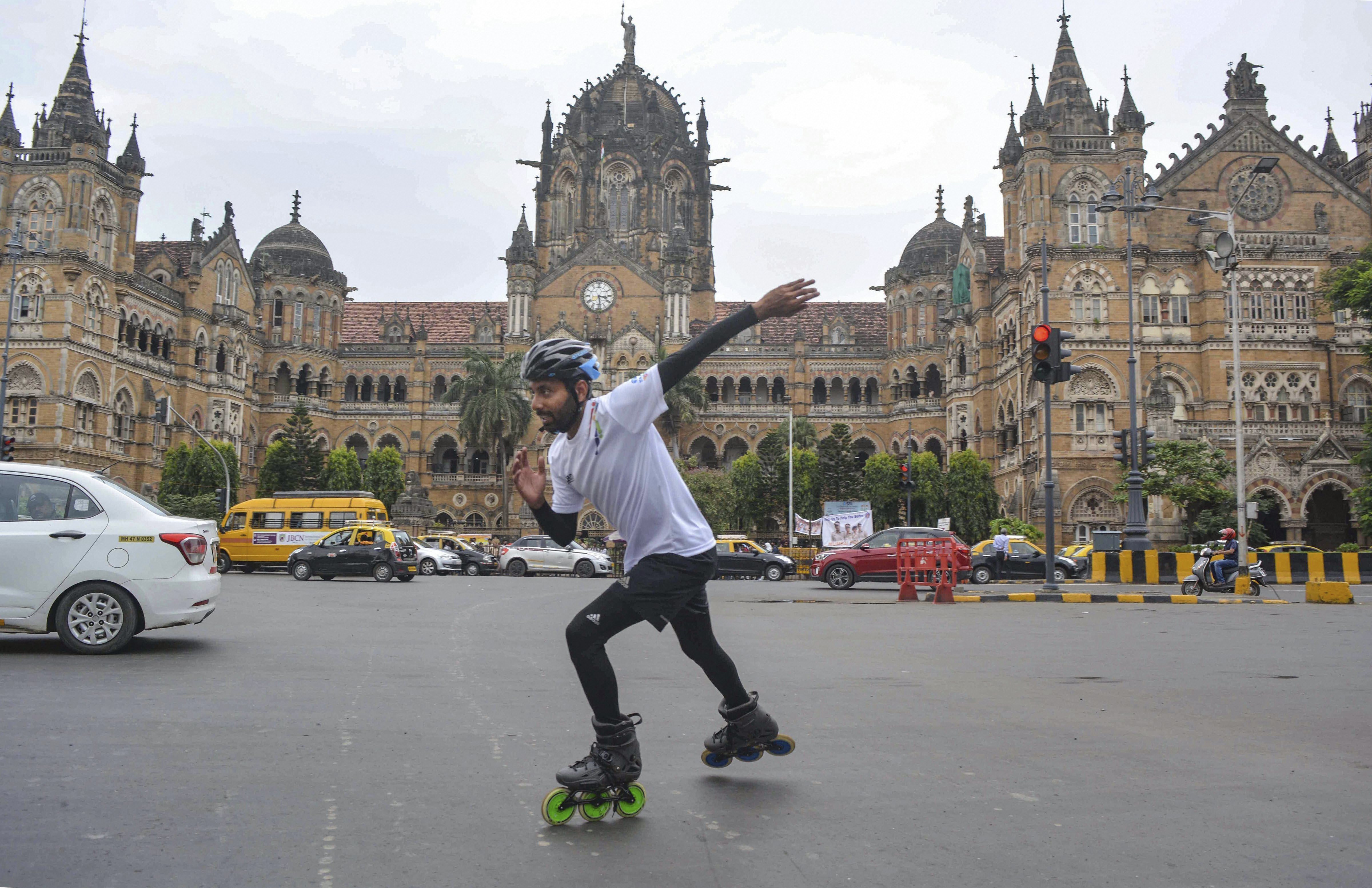 Skater Rana Uppalapati, a 37-year-old businessman from Visakhapatnam who is on a 6,000 km skating trip to educate girls, skates in the backdrop of Chhatrapati Shivaji Maharaj Terminus in Mumbai - PTI