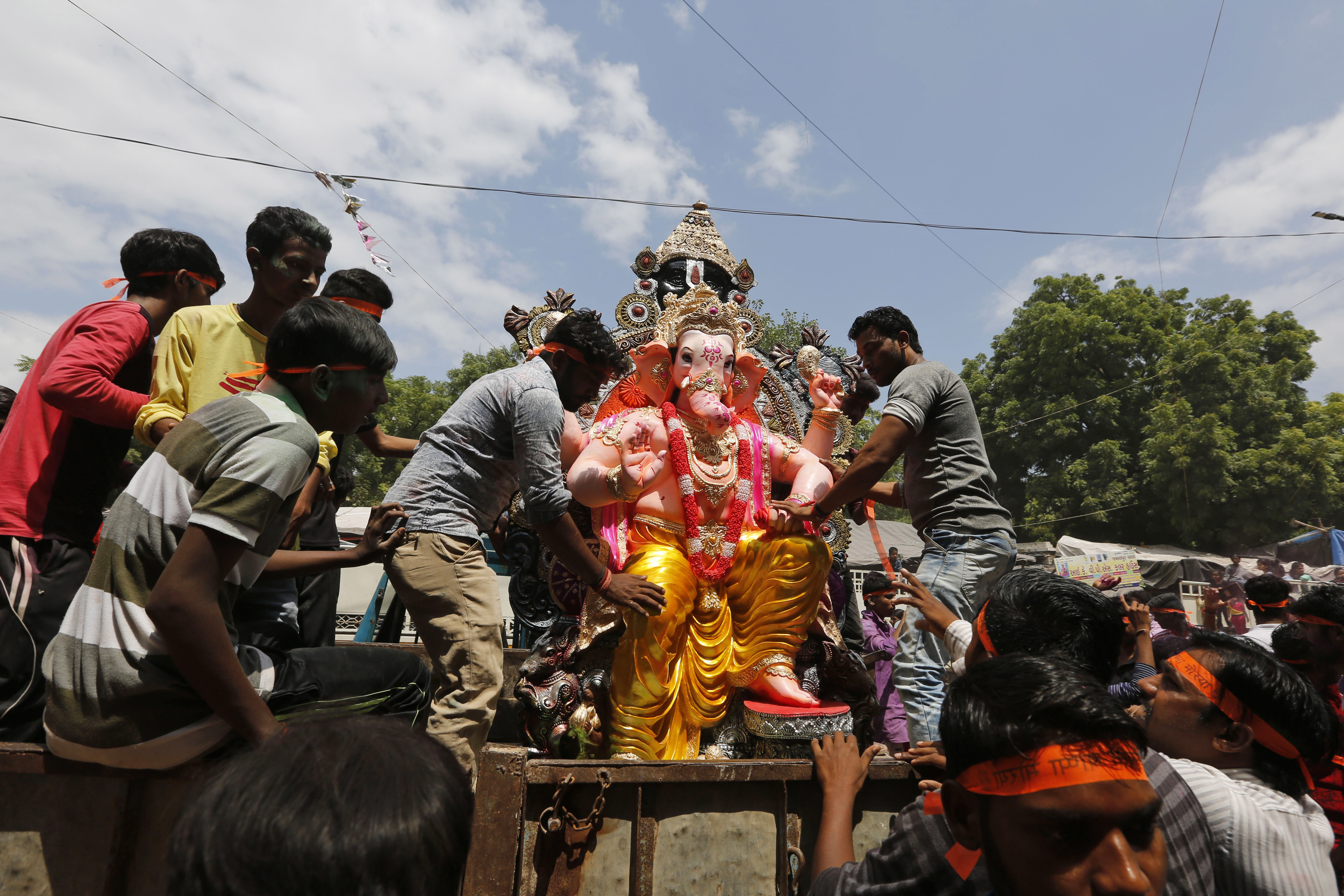 Devotees transport an idol of elephant-headed Hindu God Ganesha to a place of worship for Ganesh Chaturthi festival in Ahmadabad, India - AP