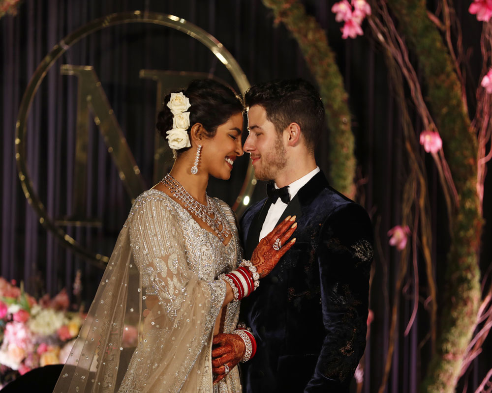 Bollywood actress Priyanka Chopra and musician Nick Jonas stand for photographs at their wedding reception in New Delhi - AP
