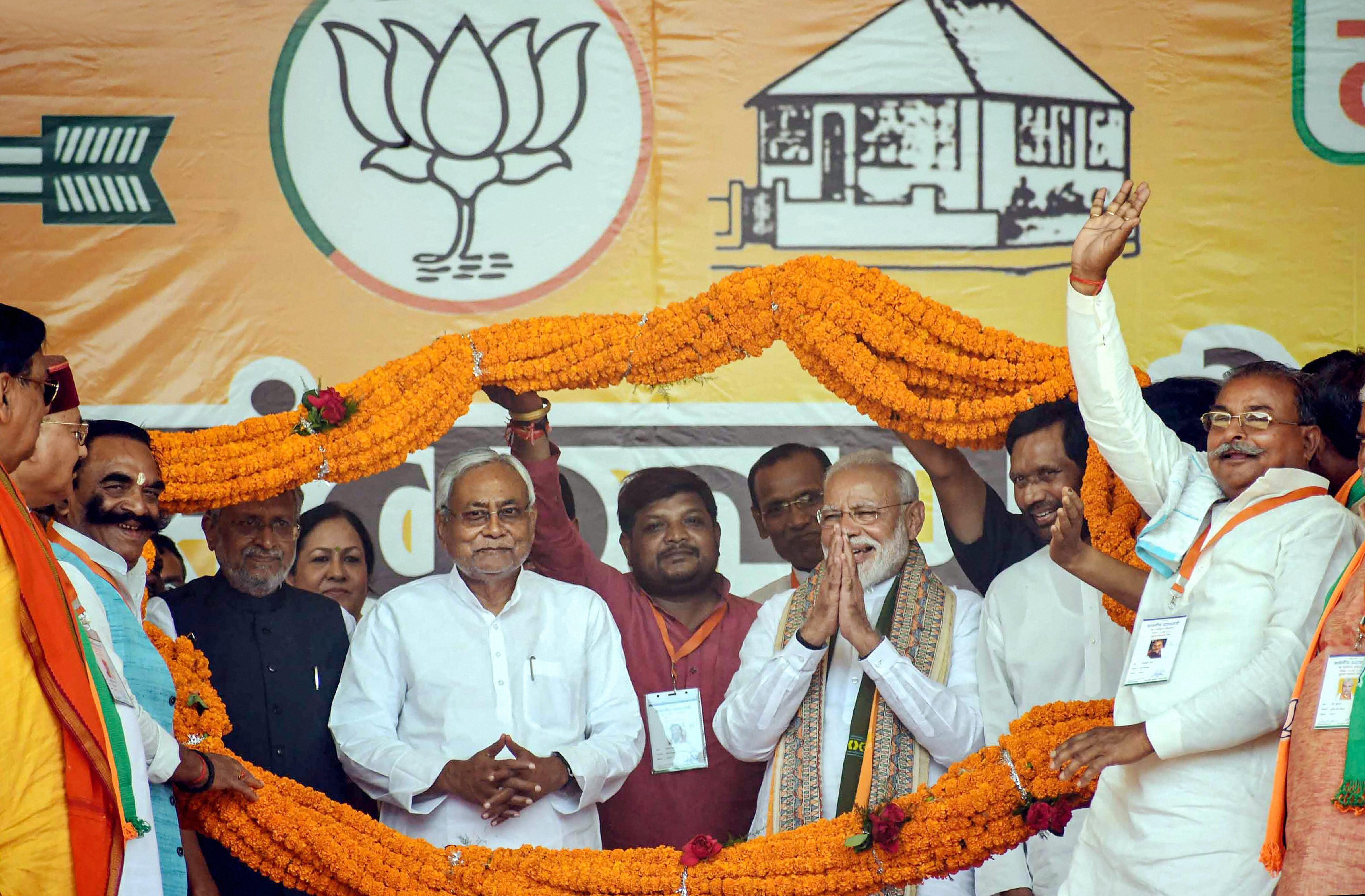 Prime Minister Narendra Modi, Bihar Chief Minister Nitish Kumar and Lok Janshakti Party (LJP) chief Ram Vilas Paswan being garlanded during an election campaign rally ahead of the last phase of the Lok Sabha polls, at Paliganj in Patna - PTI