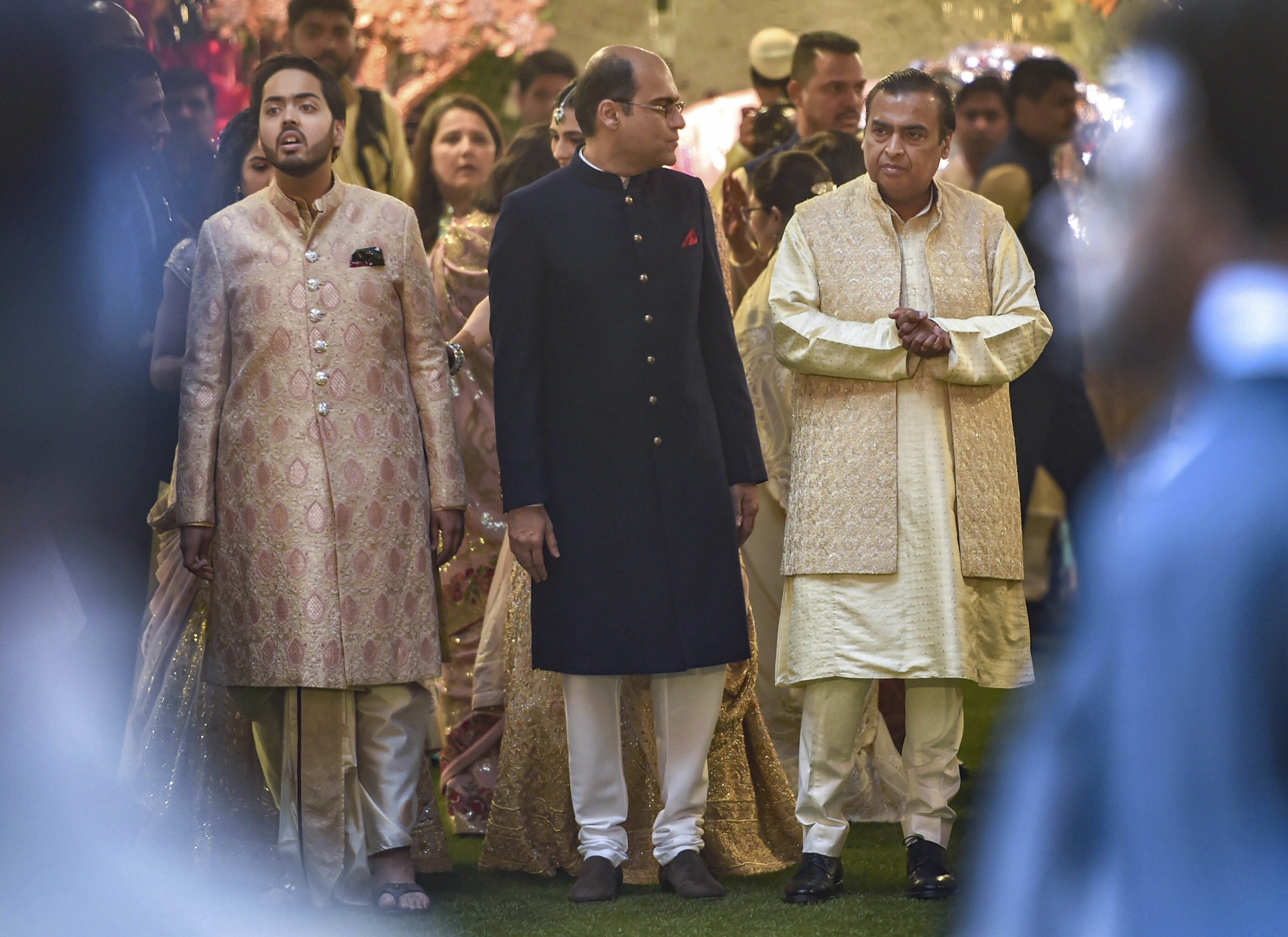 Industrialist Mukesh Ambani with son Anant waits for the arrival of the groom, Anand Piramal, at their residence, Antilla, on the wedding day, in Mumbai - PTI