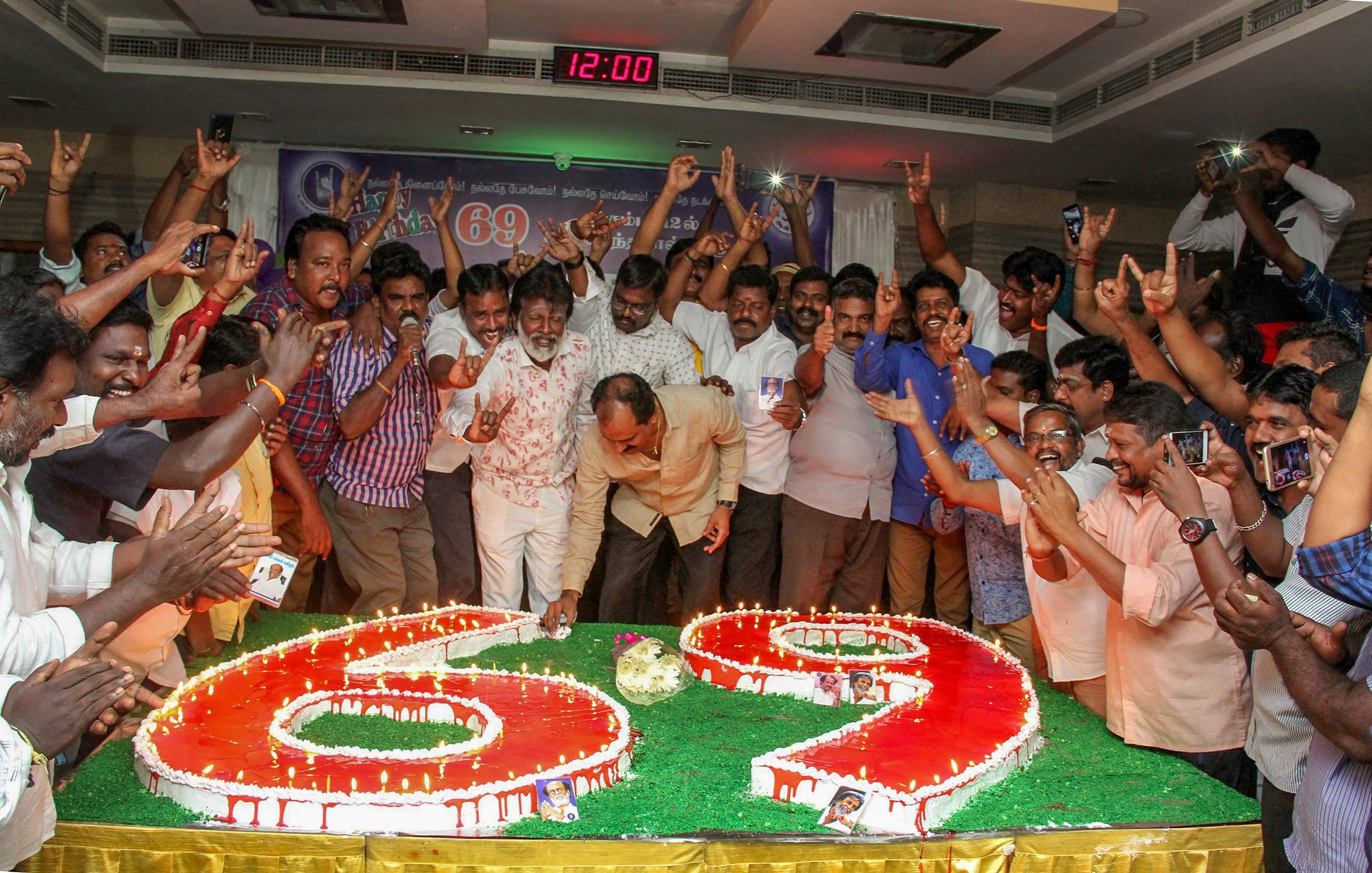 Fans of Tamil actor and politician Rajinikanth cut a mass cake on his birthday, in Chennai - PTI