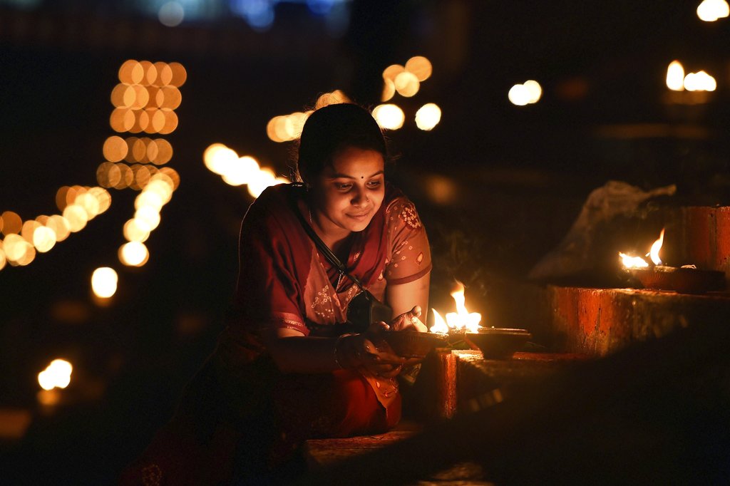 A woman lights lamps at Sri Kapaleeswarar temple which glows with lamps on the occasion of Karthigai Deepam festival at Mylaporel in Chennai - PTI