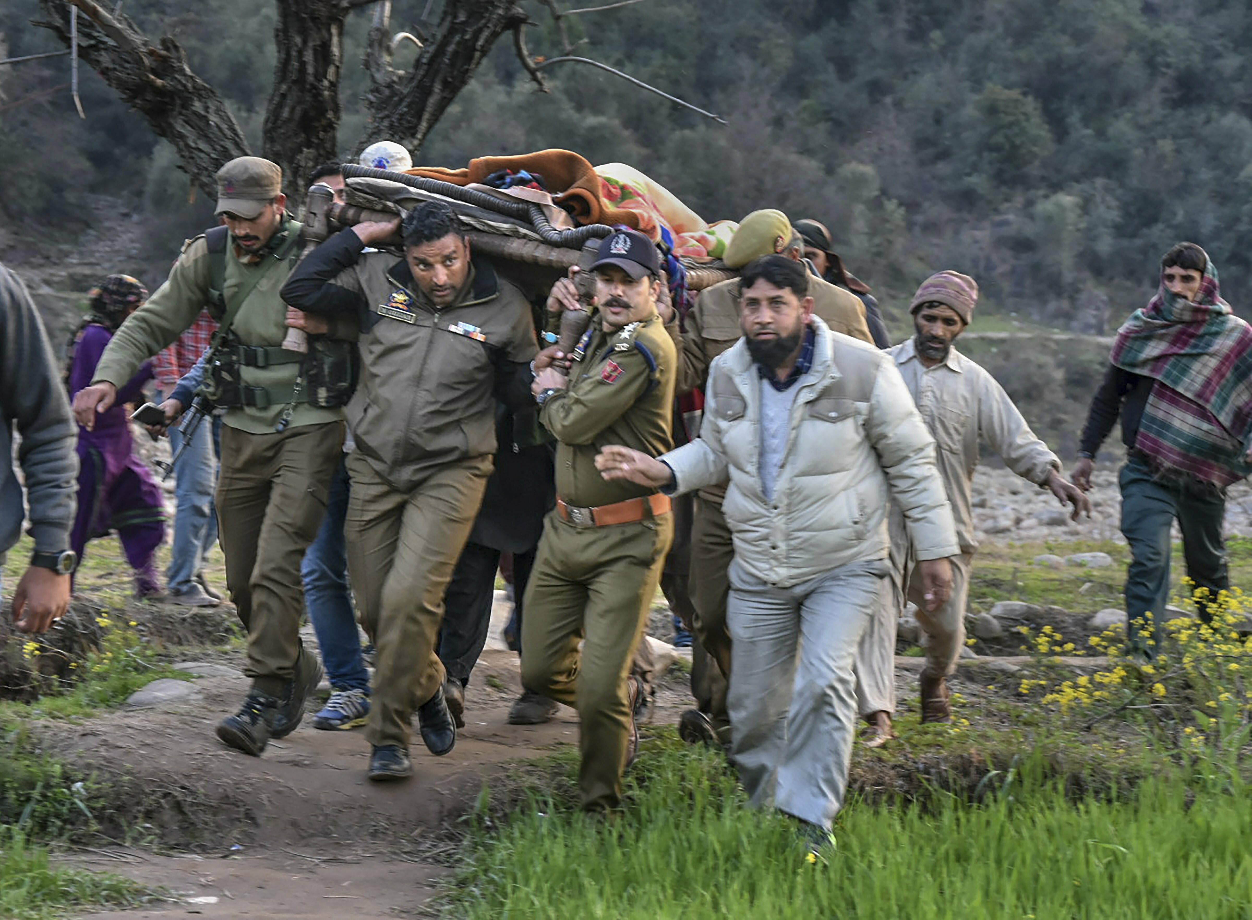 Police officials and locals carry an injured for treatment to a hospital after firing and mortar shelling by the Pakistani Army along the LoC in Krishna Ghati (KG) sector of J & K - PTI