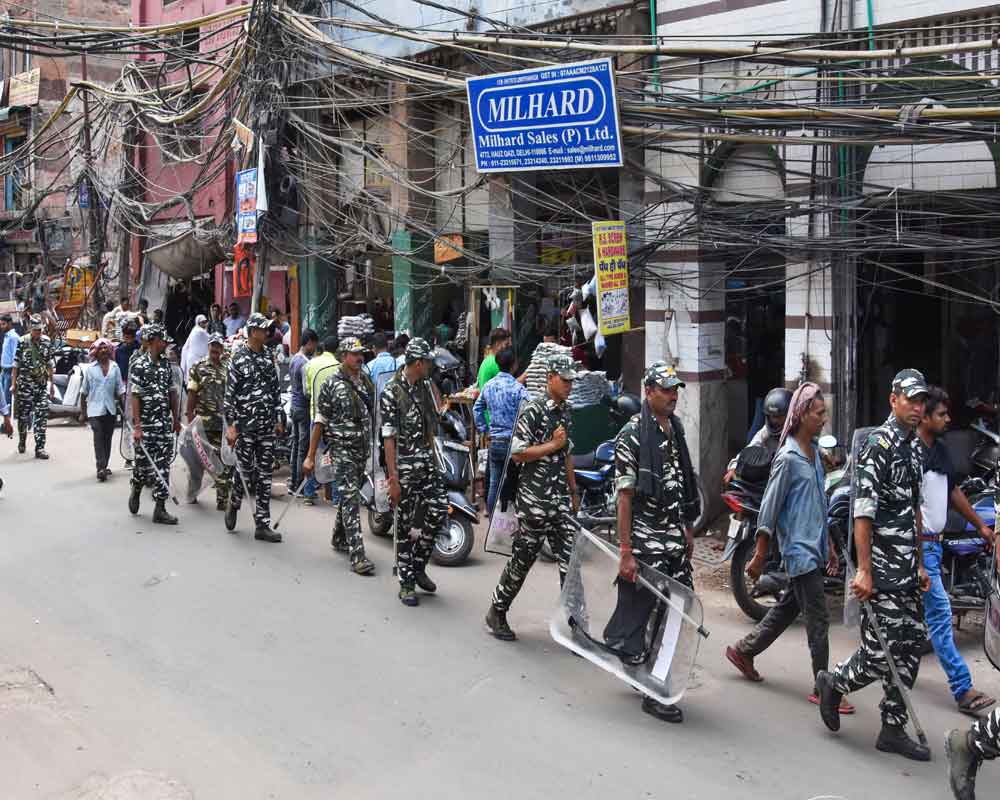 CRPF personnel patrol a street after reopening of shops in Hauz Qazi area of Chawri Bazar, old Delhi, Wednesday, July 3, 2019. The area was hit by communal tension two days ago after a row over parking of a scooter led to group clashes and vandalisation of a temple. - PTI