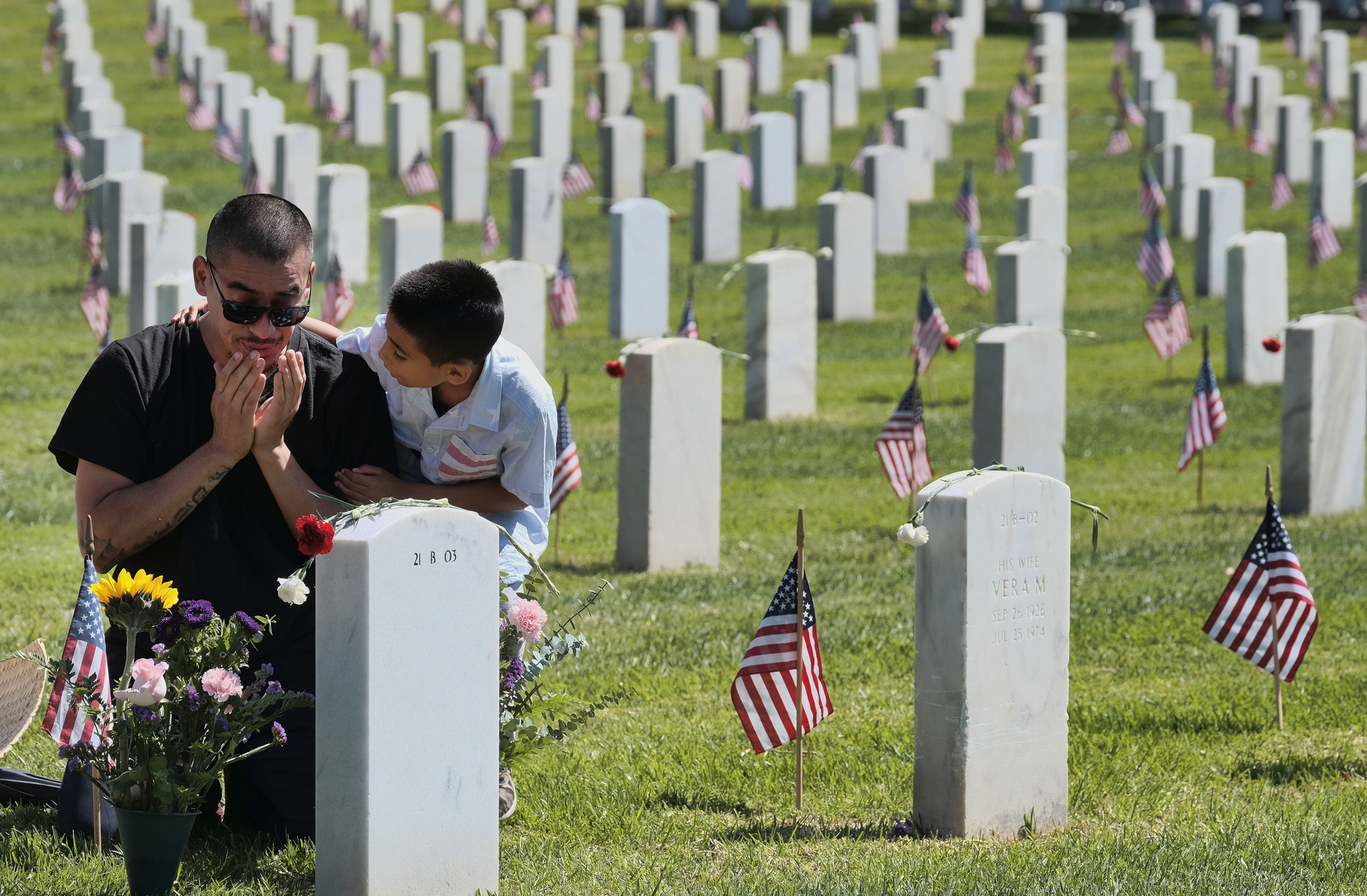 Matthieu Martinez comforts his father Ceaser Martinez as he weeps over his brother's grave on Memorial Day at the Veterans National Cemetery in Los Angeles - PTI