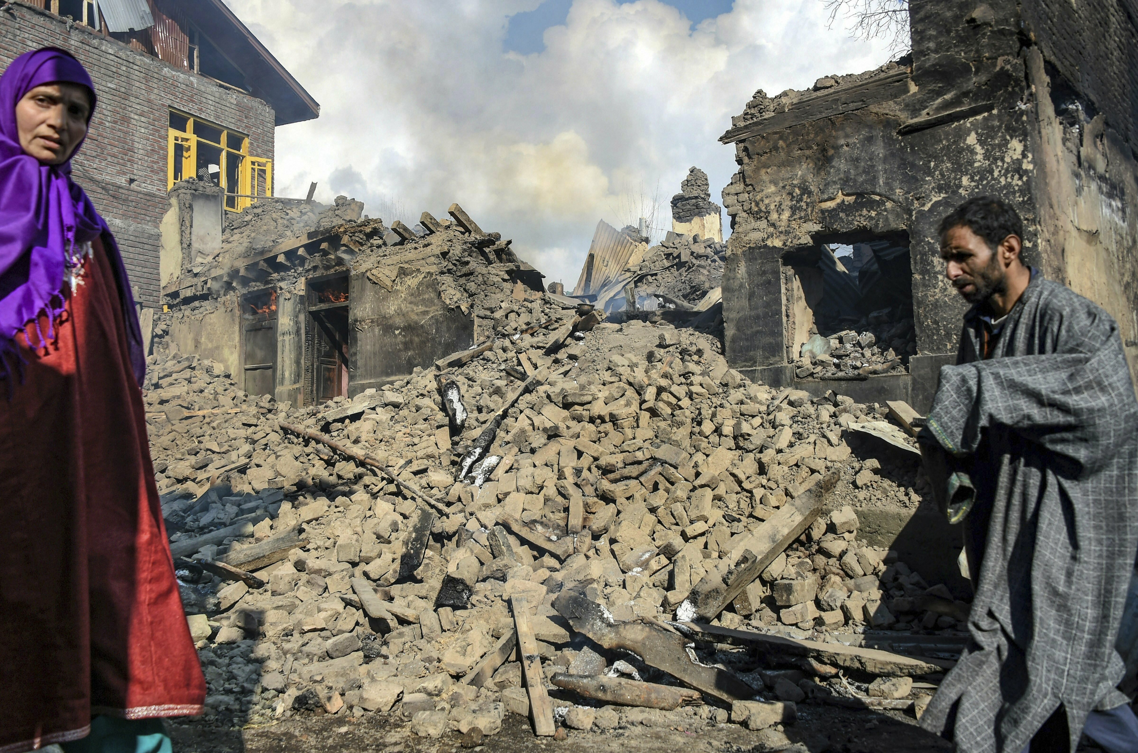 A man walks past the debris of a destroyed house after a gunbattle between security forces and militants at Reshi Mohlala area of Tral in Pulwama district of South Kashmir - AP