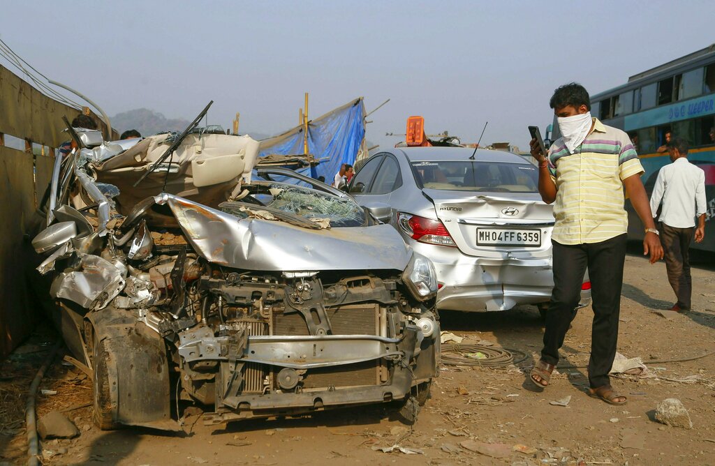 Bypasser takes photo of mangled vehicles after a sand-dumoper overtuned damaging four cars and killing one person, in Thane - PTI