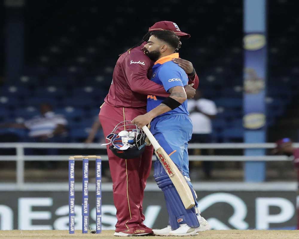 West Indies Chris Gayle, left, and India captain Virat Kohli, embrace at the end of their third One-Day International cricket match in Port of Spain, Trinidad, Wednesday, Aug. 14, 2019. India won by 6 wickets, with 15 balls remaining - PTI