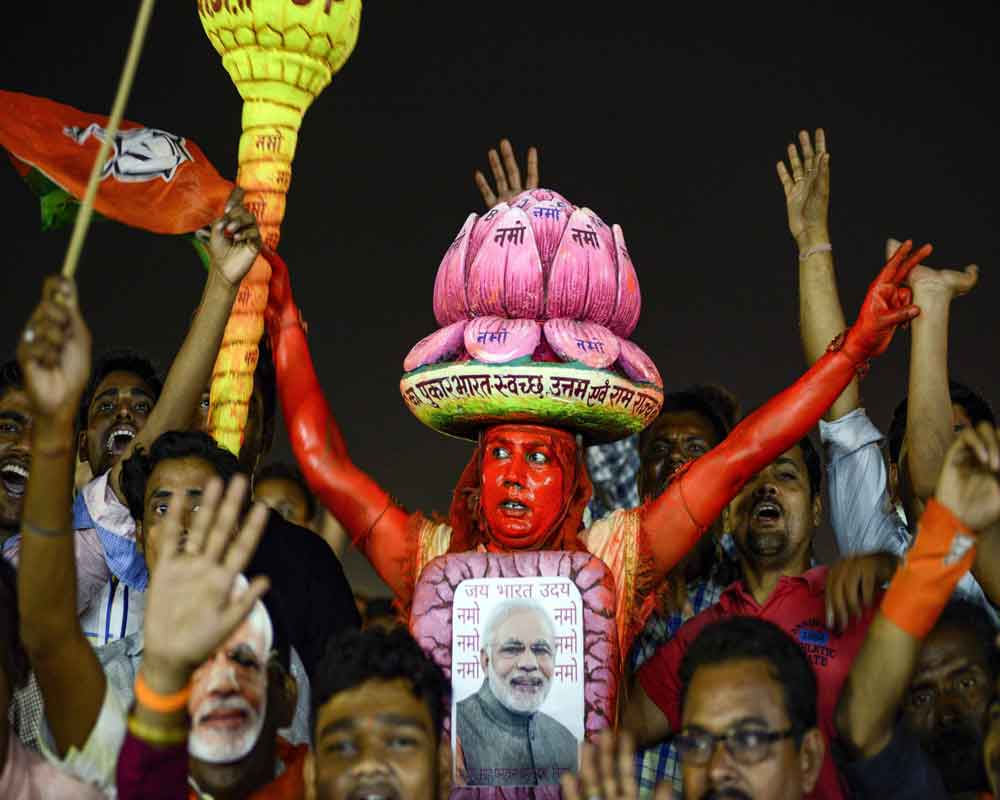 BJP supporter wears a poster of Prime Minister Narendra Modi during Vijay Sankalp Sabha, an election campaign by Modi for the Lok Sabha polls, in Bhubaneswar - PTI