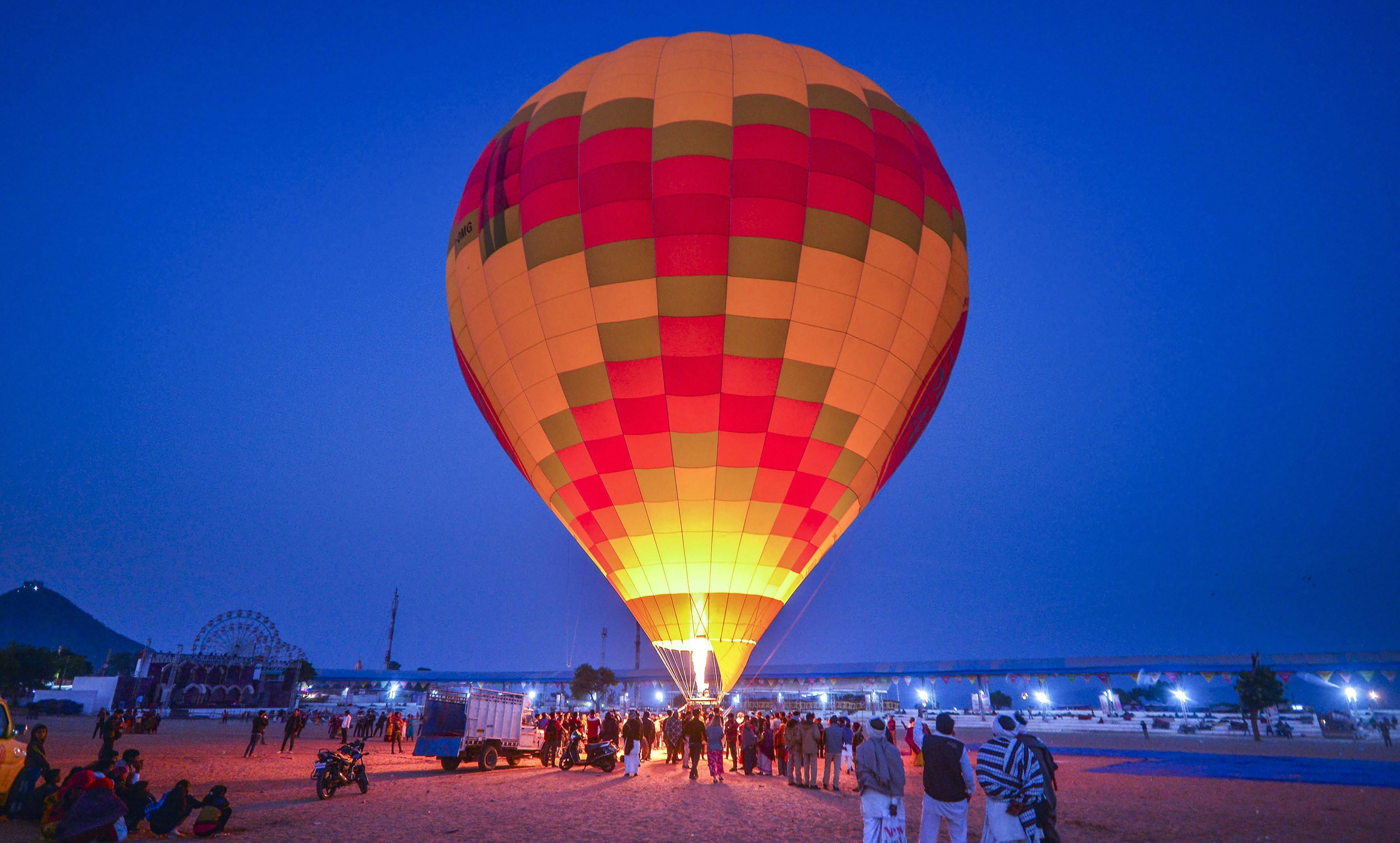 People gather near a hot air balloon, at Pushkar Camel Fair in Pushkar - PTI