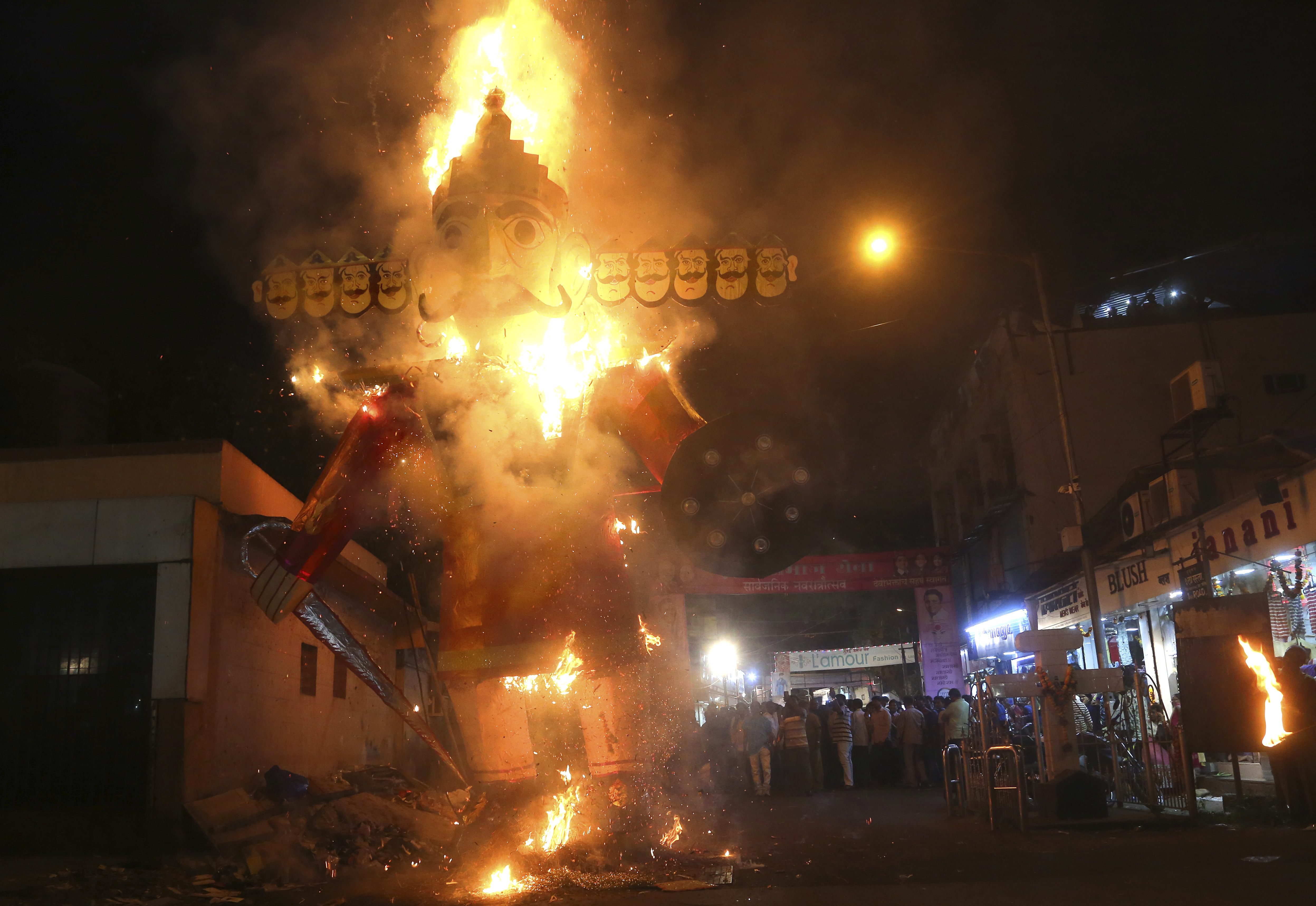 People watch an effigy of Ravana burn during Dussehra festival in Mumbai - AP
