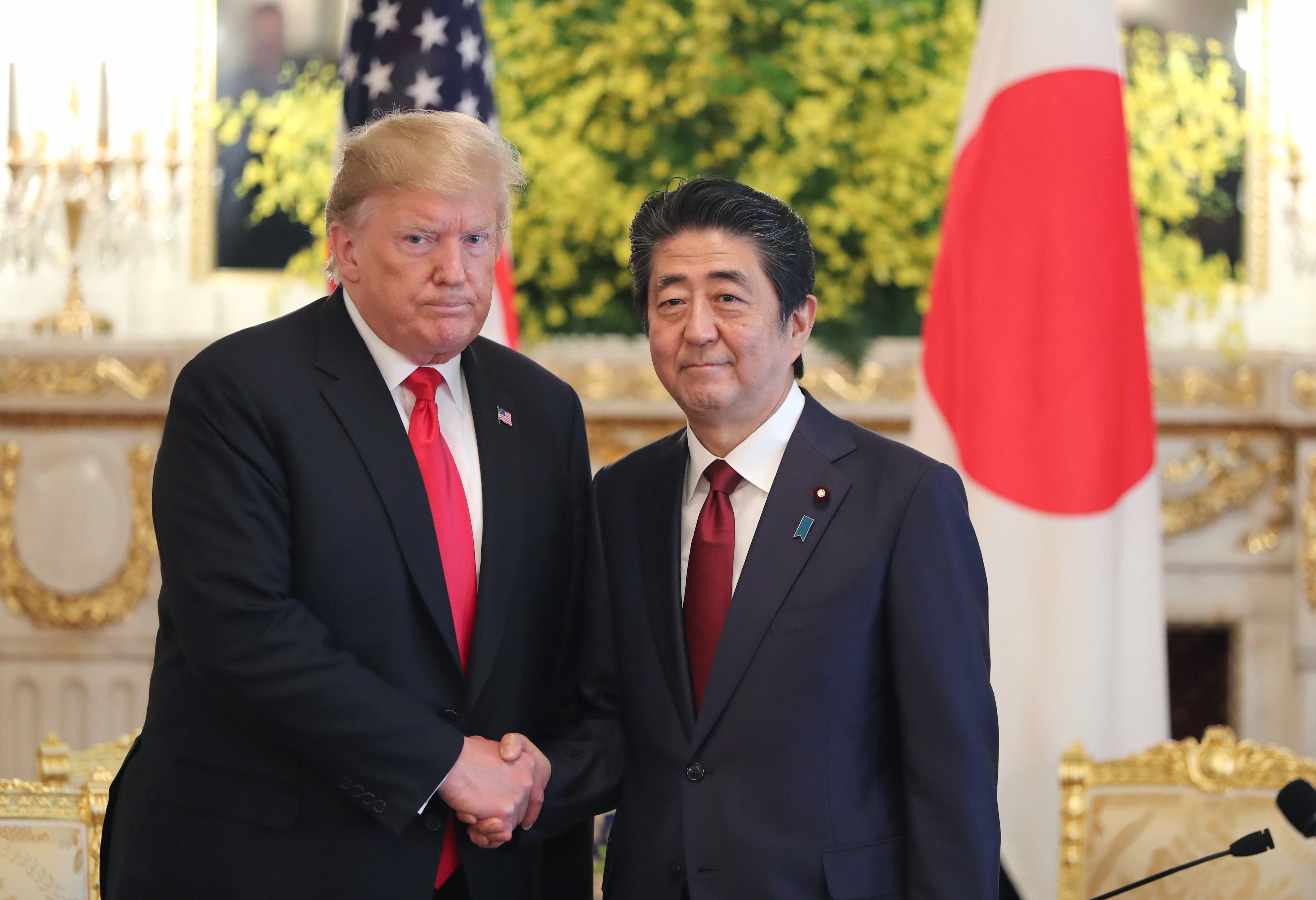 U.S. President Donald Trump, left, and Japanese Prime Minister Shinzo Abe shake hands prior to their meeting at Akasaka Palace, Japanese state guest house in Tokyo - PTI