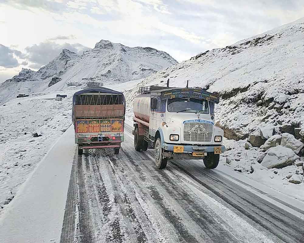 Vehicles ply on the snow-covered Manali-Leh road following fresh snowfall, near Rohtang Pass in Kullu - PTI