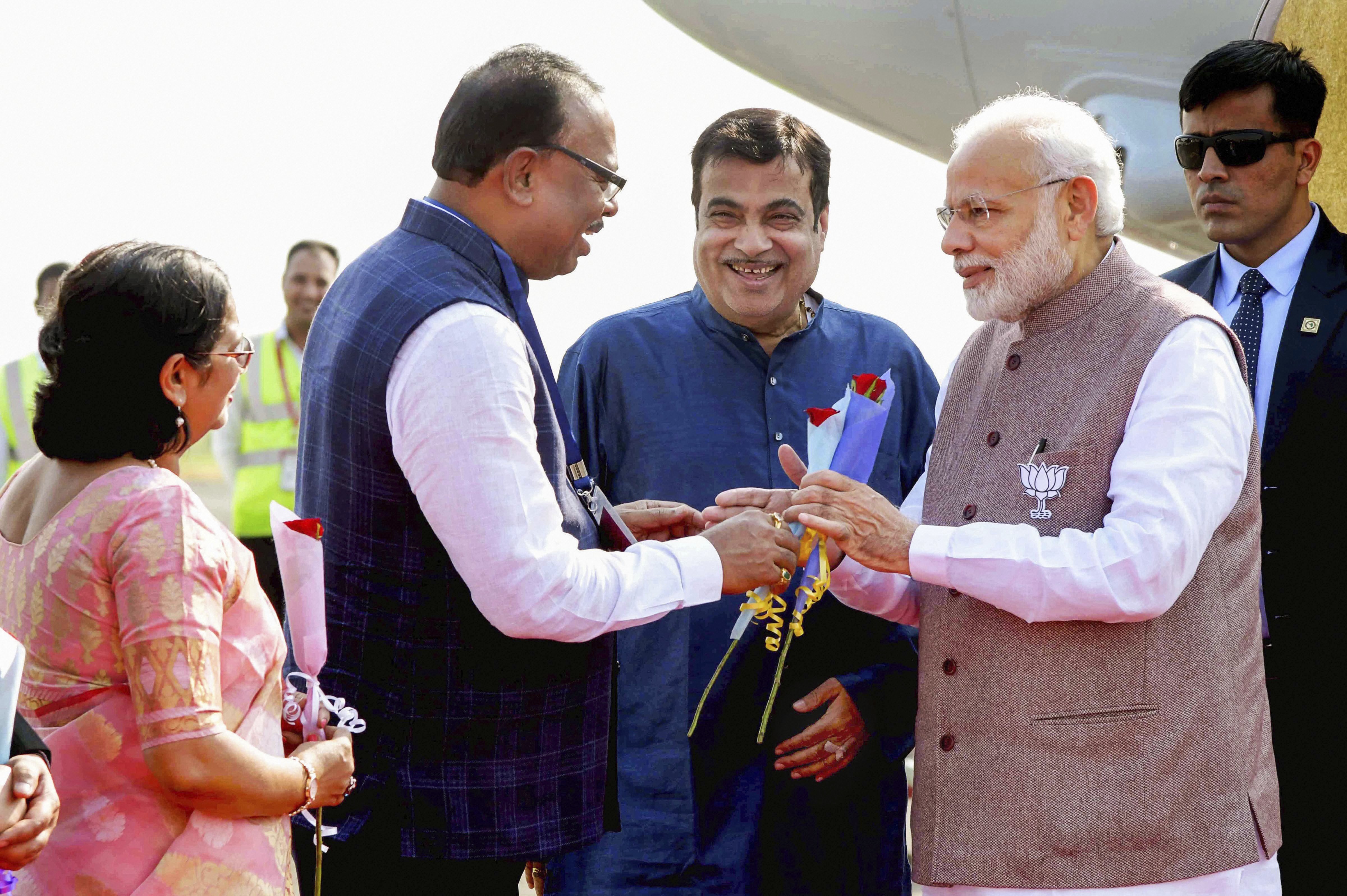 Prime Minister Narendra Modi being received by Maharashtra Energy Minister Chandrashekhar Bawankule as Union Minister for Road Transport Nitin Gadkari looks on, upon his arrival at the airport in Nagpur - PTI