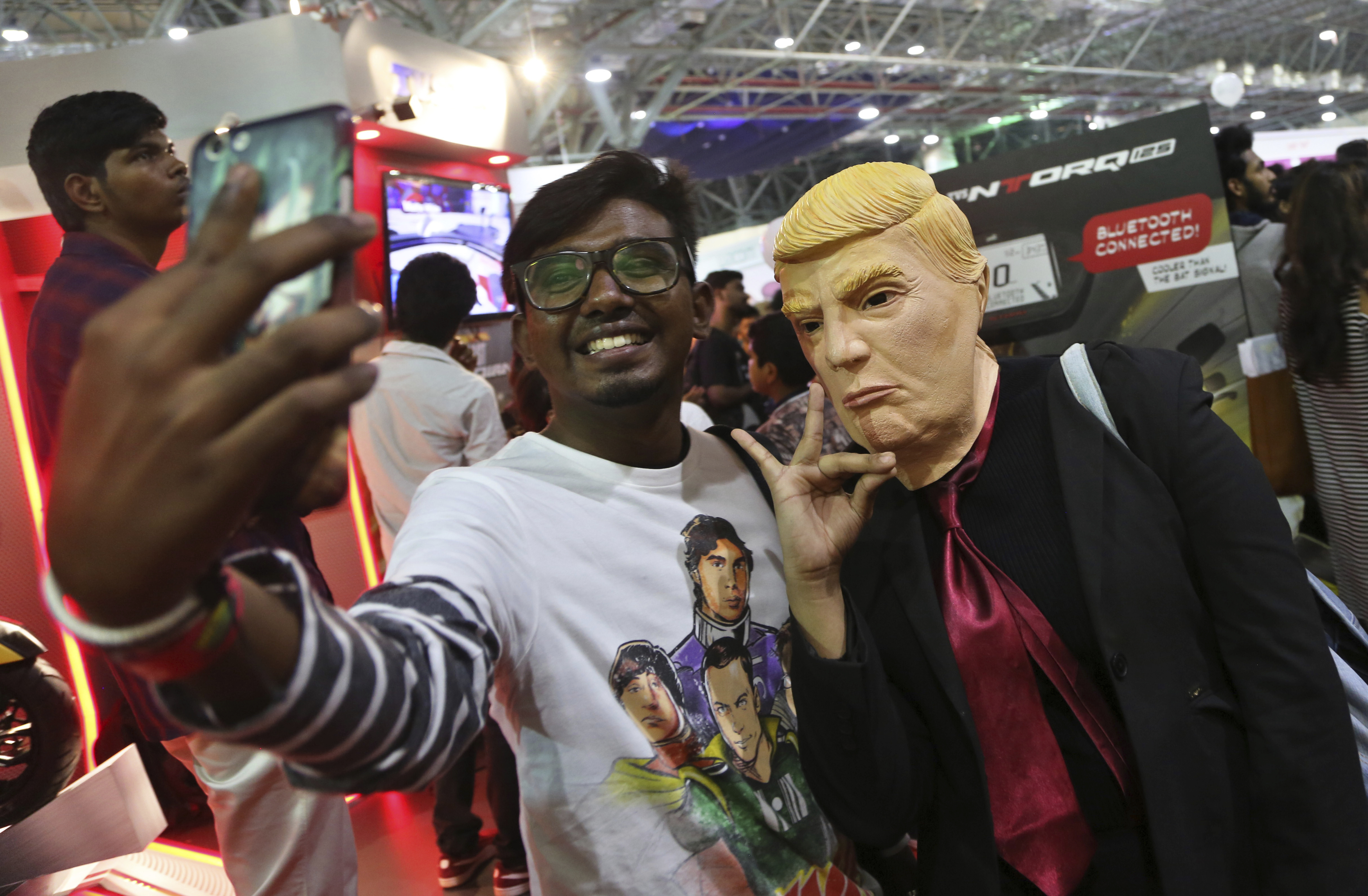 A man takes a selfie with a girl dressed as U.S. President Donald Trump at the Bengaluru Comic Con in Bangalore - AP