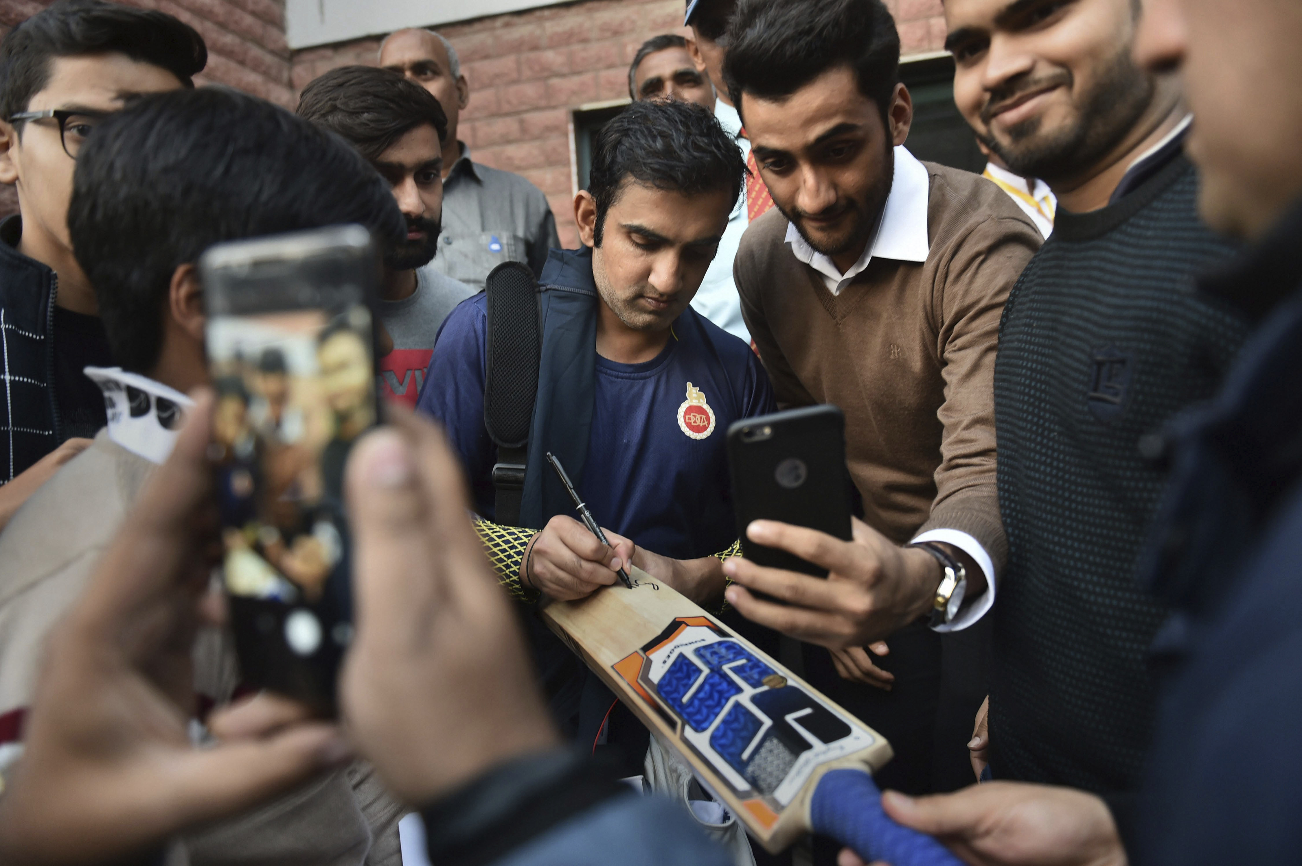 Delhi cricketer Gautam Gambhir gives an autograph after Ranji Trophy group league match between Delhi and Andhra at Feroz Shah Kotla Ground, in New Delhi - PTI