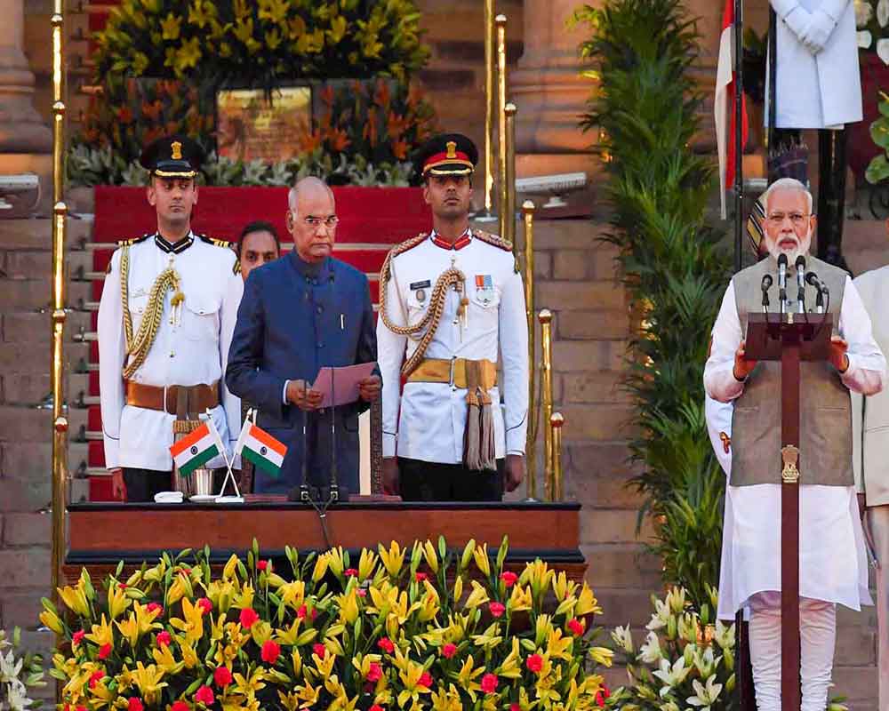 Prime Minister Narendra Modi greets while taking oath of office and secrecy for the second consecutive term, during a swearing-in ceremony at the forecourt of Rashtrapati Bhawan in New Delhi - PTI