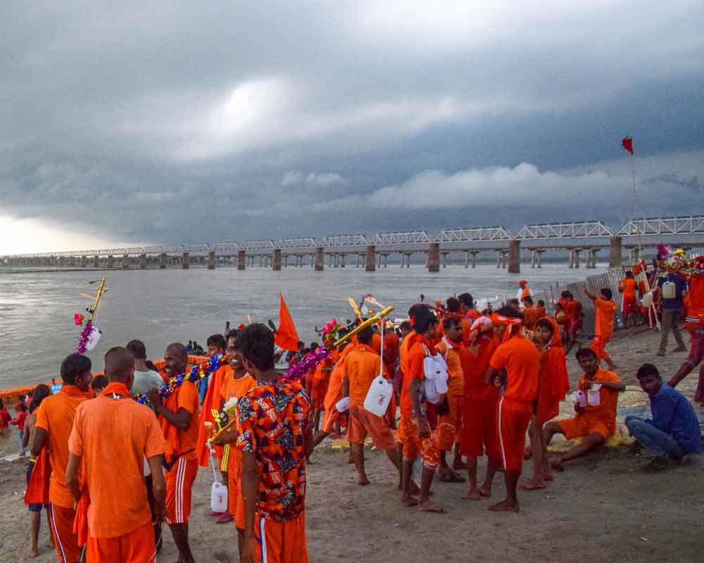 Hindu devotees of Lord Shiva collect water from river Ganges for their walk towards Kashi Vishwanath Temple during the holy month of Shravan - PTI