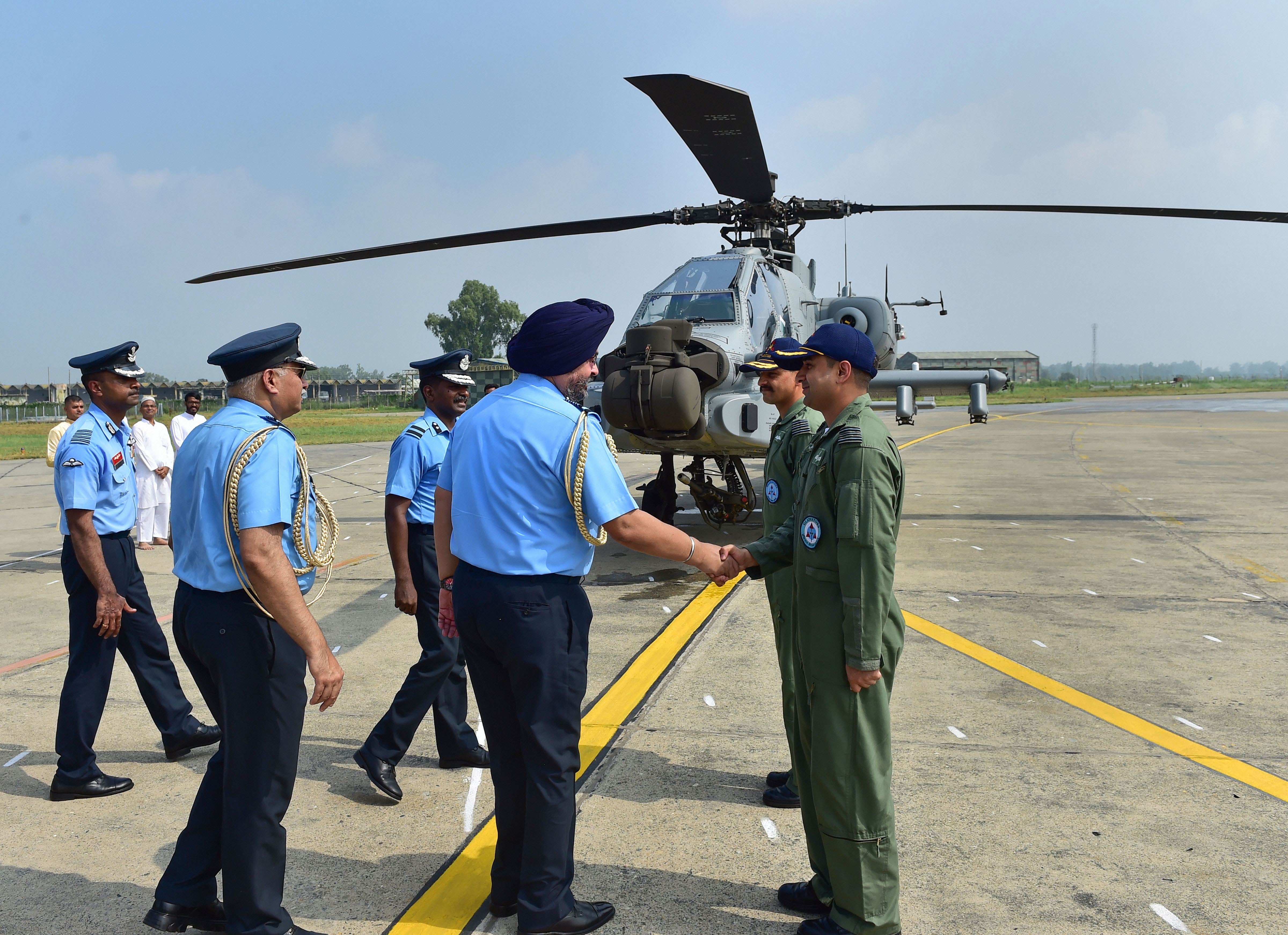Air Chief Marshal Birender Singh Dhanoa greets the pilots of an Apache AH-64E attack helicopter during its induction - PTI