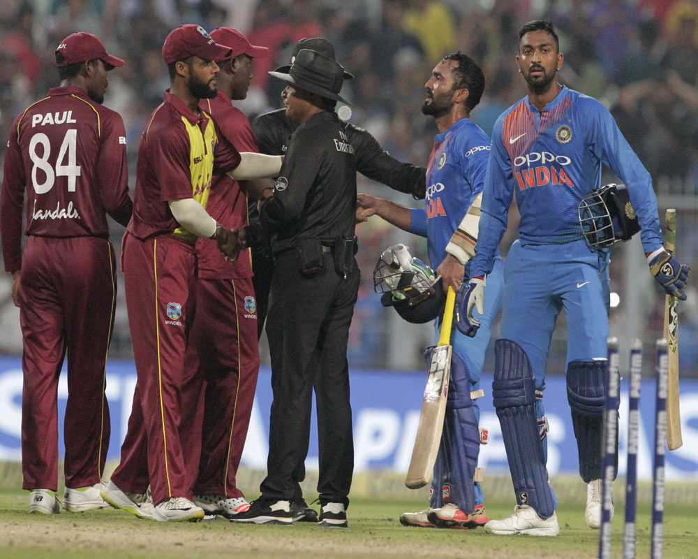 India's Krunal Pandya, right, and teammate Dinesh Karthik, second right, leave the field after their win over West Indies in the first Twenty20 international cricket match between India and West Indies in Kolkata - AP