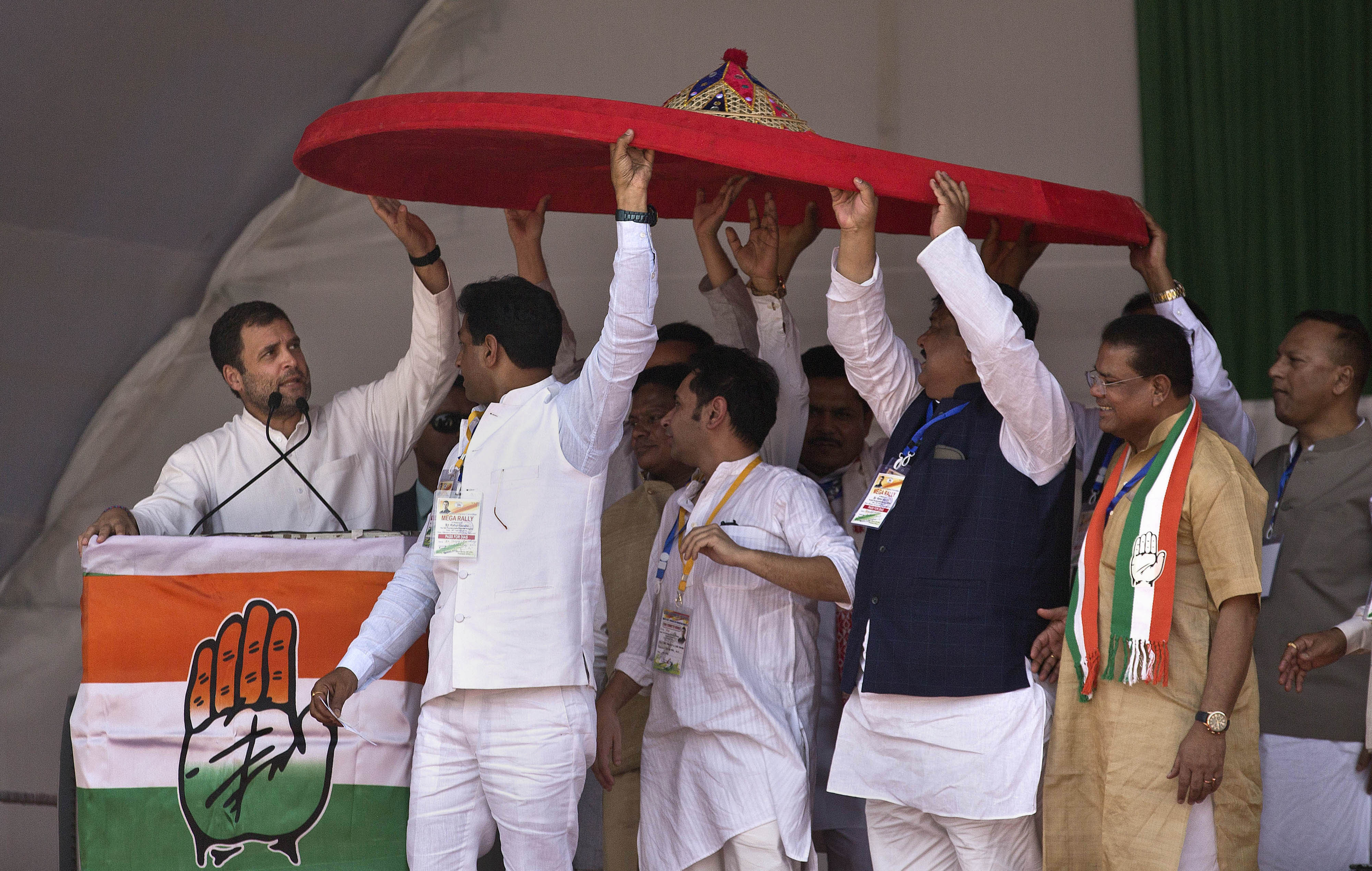 India's Congress party President Rahul Gandhi, left, holds a giant traditional Assamese hat called a Japi during a public rally in Gauhati - AP