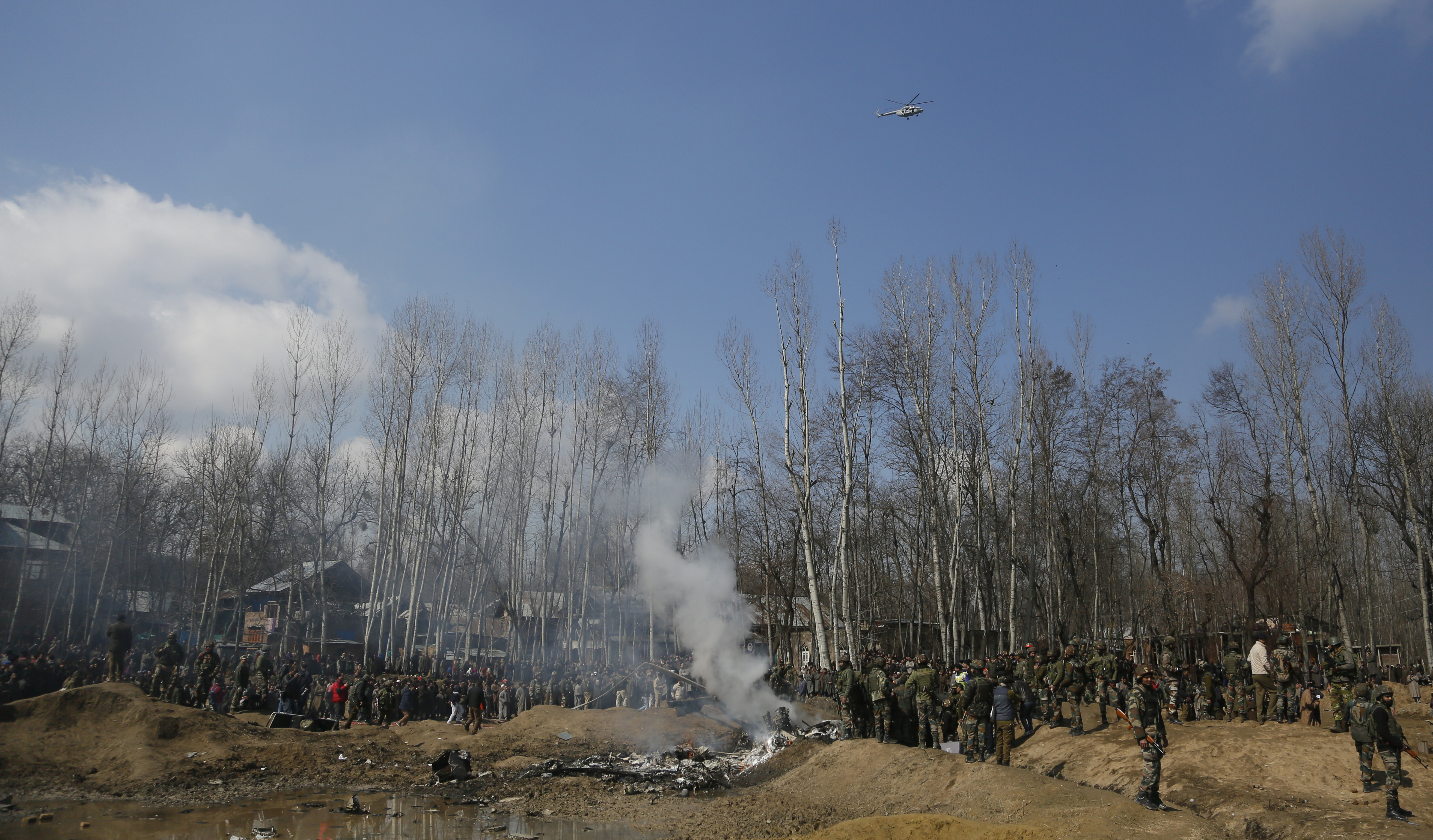 Kashmiri villagers and Indian soldiers gather near the wreckage of an Indian aircraft after it crashed in Budgam area, outskirts of Srinagar - AP