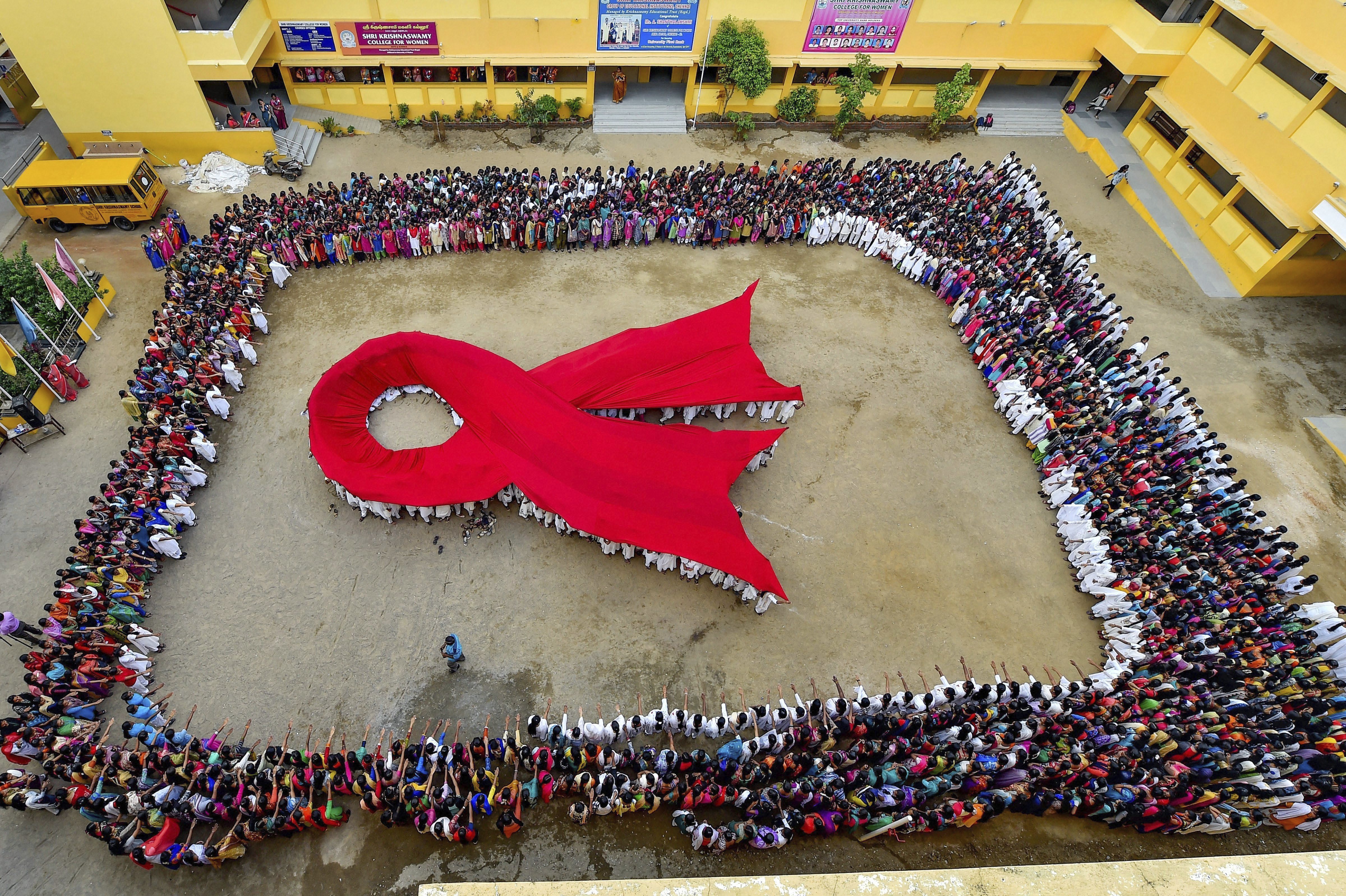 Students make a formation of AIDS symbol on the eve of World AIDS Day, in Chennai - PTI
