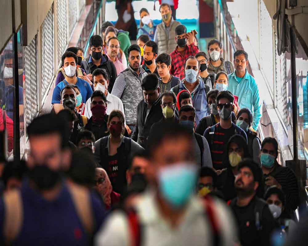 Passengers wear masks a precautionary measure against the coronavirus pandemic, at a railway station, in Jammu - PTI