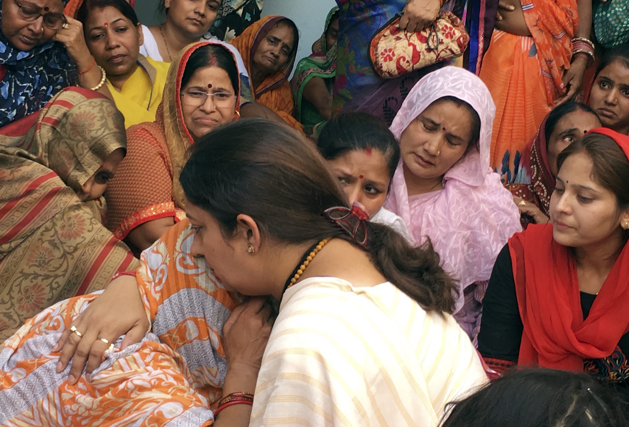 BJP MP Smriti Irani consoles the family members of former village head (pradhan) Surendra Singh, who was shot dead unidentified miscreants, at his village in Amethi, Sunday, May 26, 2019. Singh is believed to have worked closely with Irani and was part of the BJP team that did the ground work in Amethi - PTI