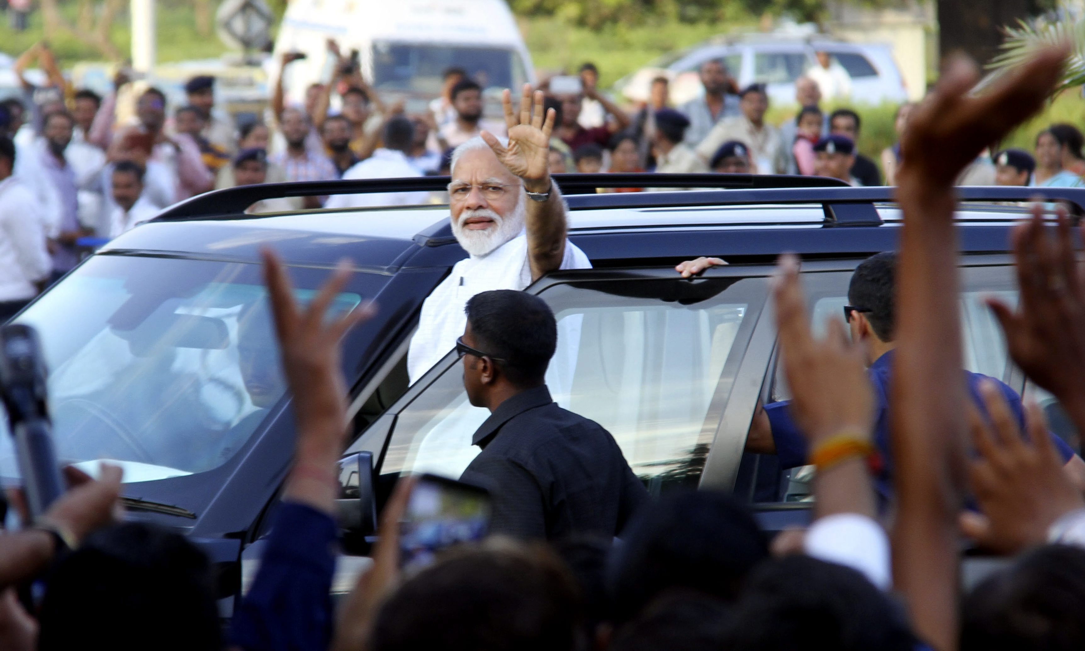Prime Minister Narendra Modi waves at the supporters on his arrival at the airport in Ahmedabad - PTI