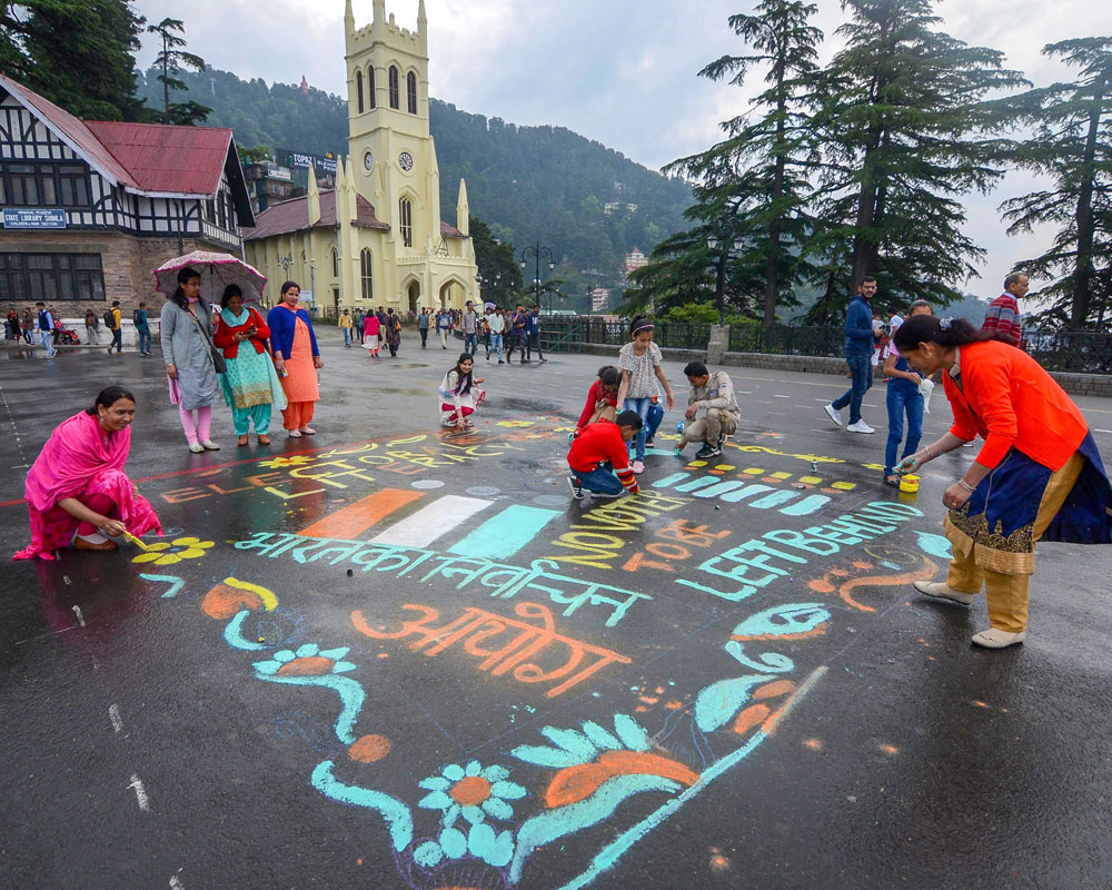Volunteers make rangoli on a street to spread election awareness on the eve of the seventh and final phase of Lok Sabha polls, in Shimla - PTI
