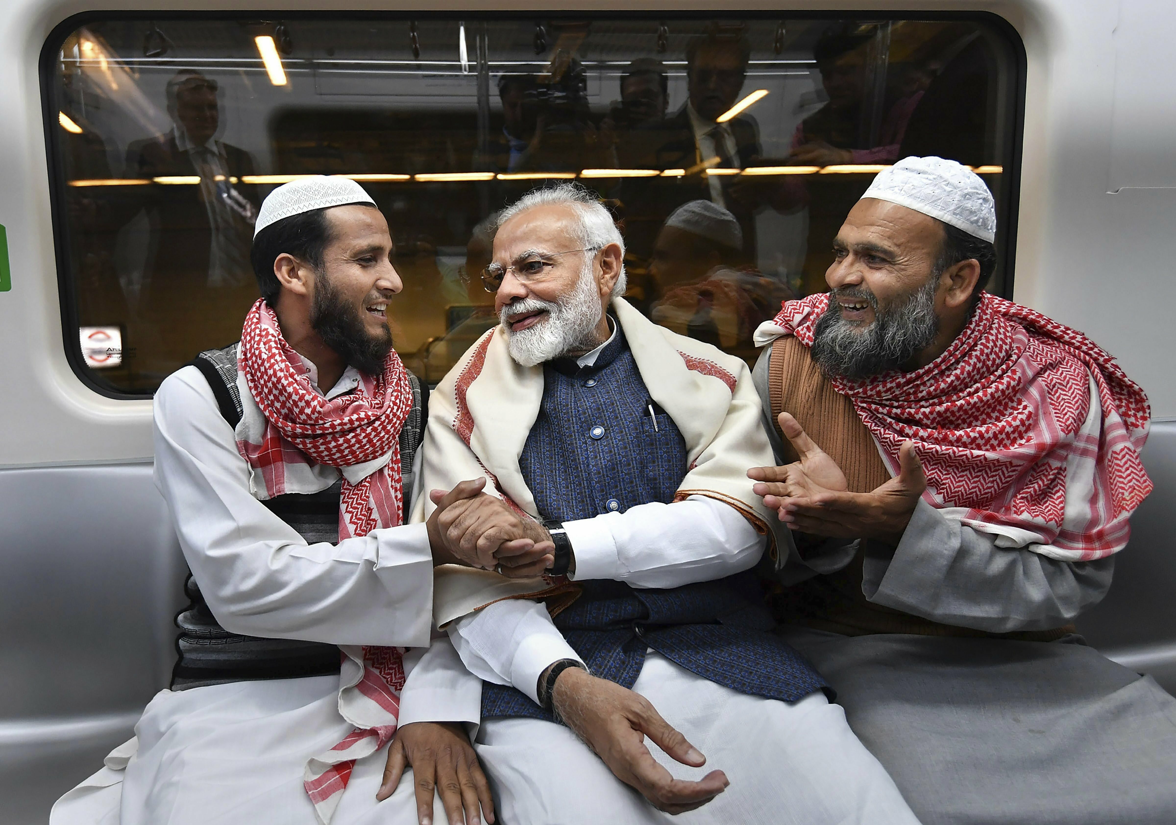 Prime Minister Narendra Modi interacts with commuters in the metro train on his way to attend the Gita Aradhana Mahotsav at ISKCON temple, in south Delhi's East of Kailash - PTI