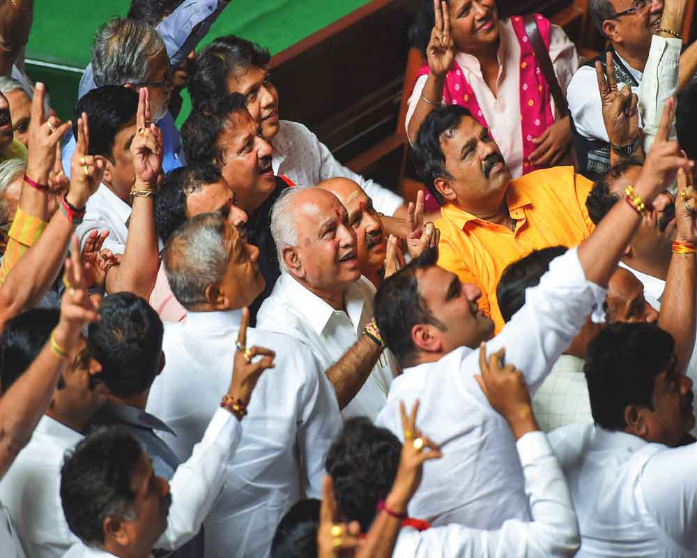 BJP State President BS Yeddyurappa with his party MLAs show victory sign after HD Kumaraswamy lost the vote of confidence during Assembly Session at Vidhana Soudha, in Bengaluru, Tuesday - PTI