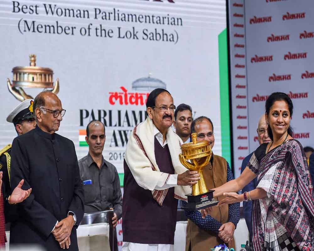 Vice President M Venkaiah Naidu present the 'Best Woman Parliamentarian Award' to Nationalist Congress Party (NCP) leader Supriya Sule as NCP chief Sharad Pawar looks on, during the  Lokmat Parliamentarian Award 2019 - PTI