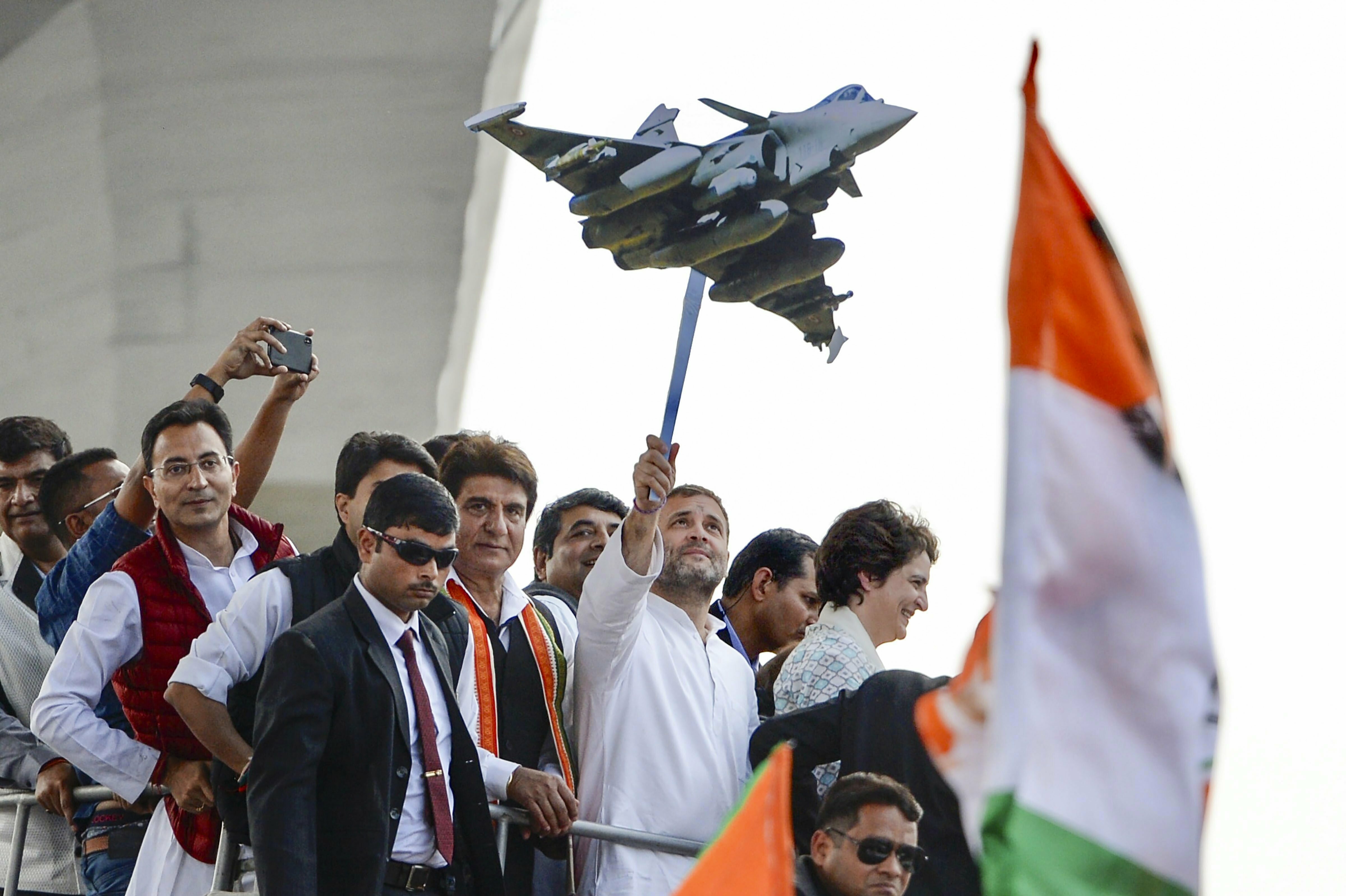 Congress President Rahul Gandhi holds a model of Rafale aircraft during a roadshow along with the party general secretaries Priyanka Gandhi Vadra and Jyotiraditya Scindia, in Lucknow - PTI