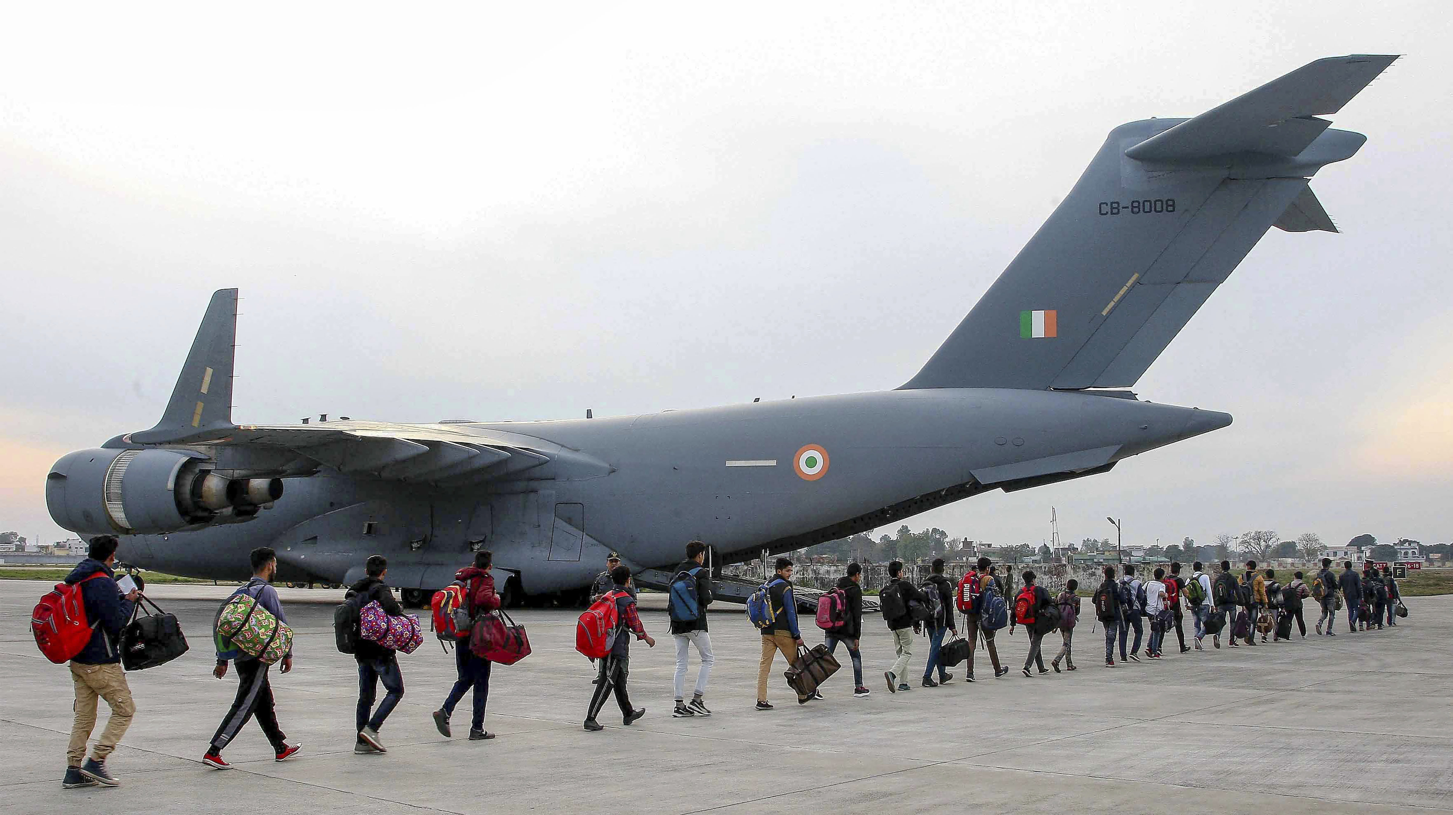 Stranded Kashmir bound passengers queue up to board a C-17 aircraft of the Indian Air Force for the valley, in Jammu - PTI