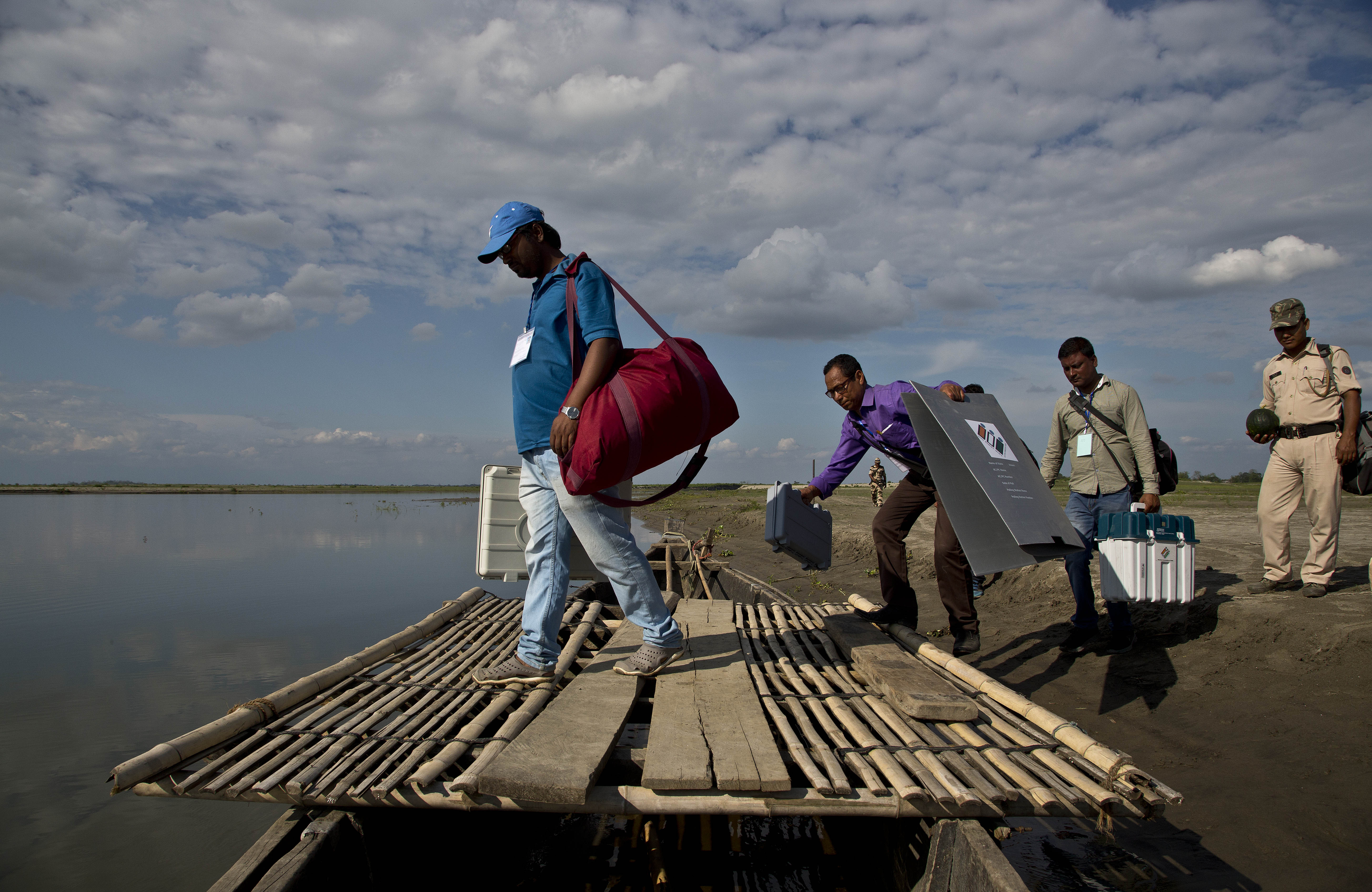 Indian election officials and paramilitary soldiers with election materials board on a country boat to cross the river Brahmaputra on the eve of first phase of general election in Majuli, Assam - AP