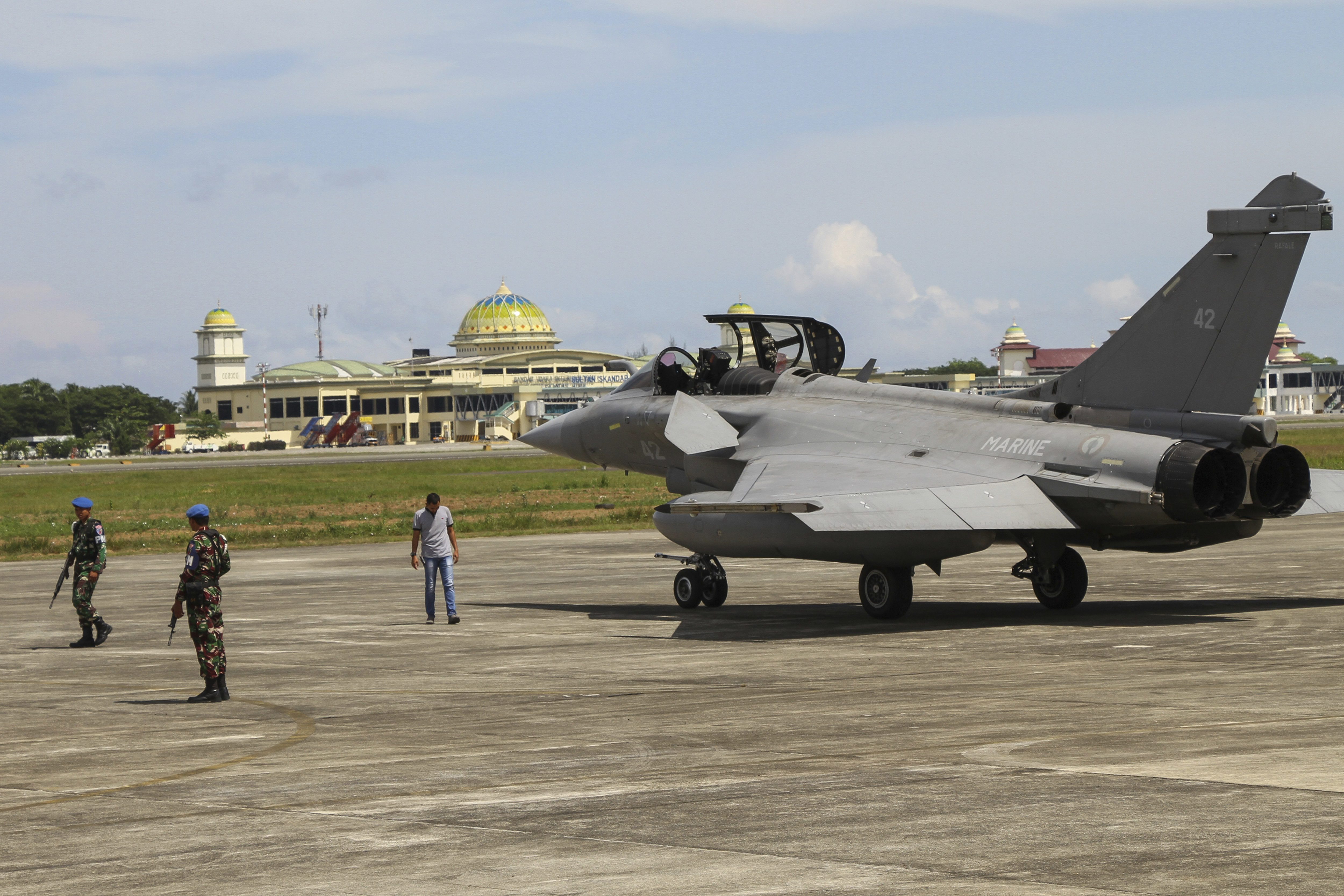 Indonesian military personnel stand guard near one of seven French Navy Rafale jet fighters parked on the tarmac at Sultan Iskandar Muda Air Base in Aceh Besar, Indonesia - PTI