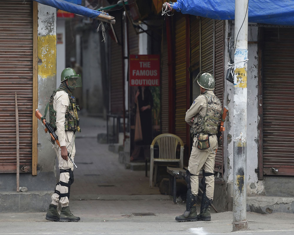 Security personnel stand guard during restrictions at Downtown in Srinagar - PTI