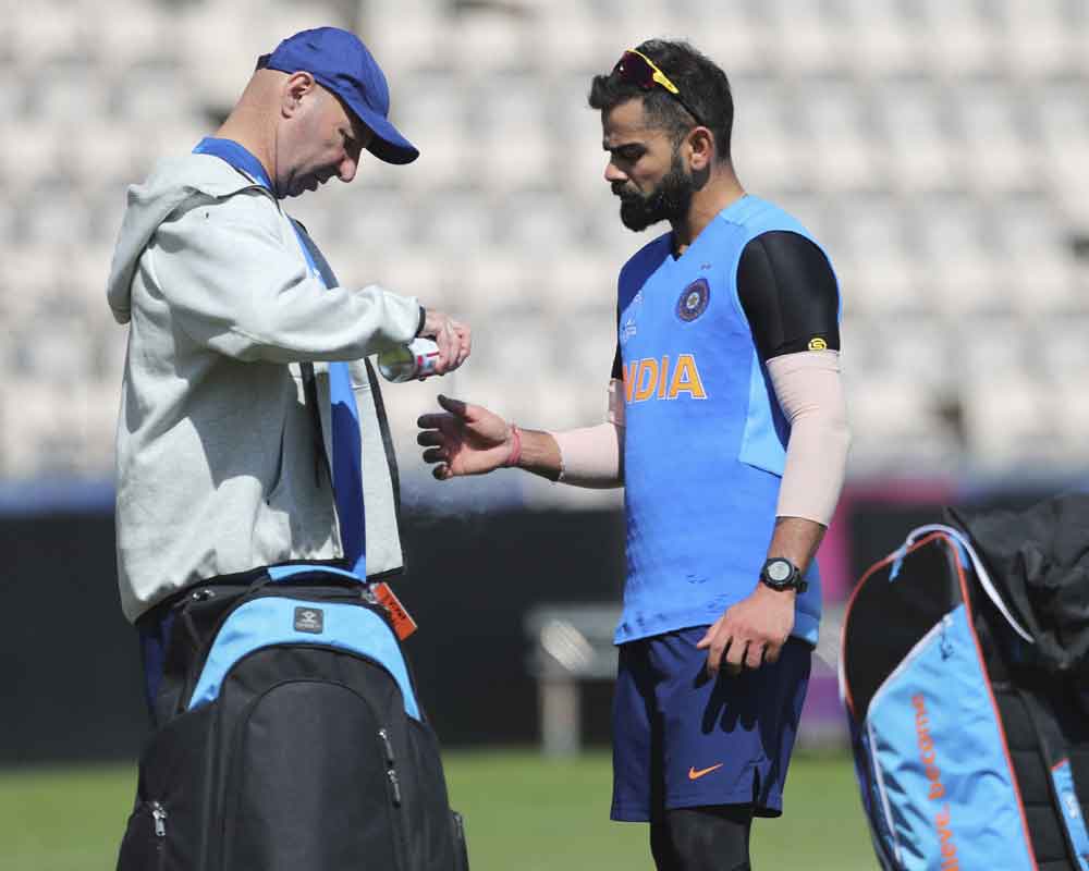 Indian team physiotherapist Patrick Farhart, left, sprays the thumb of India's captain Virat Kohli after hurting it during a training session ahead of their Cricket World Cup match against South Africa at Ageas Bowl in Southampton, England - PTI