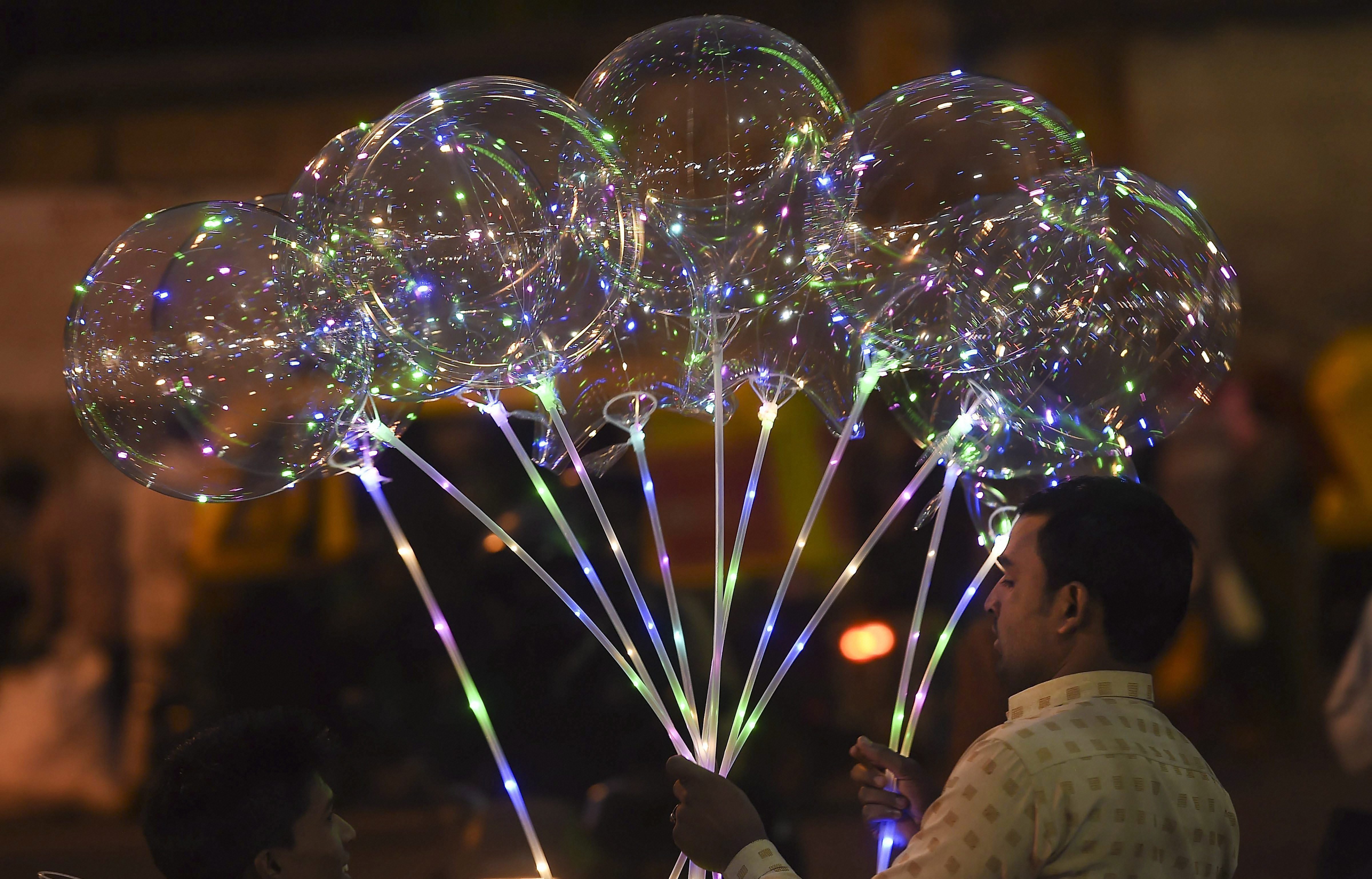 A roadside vendor sells the LED balloons ahead of Christmas celebrations, in Bengaluru - PTI