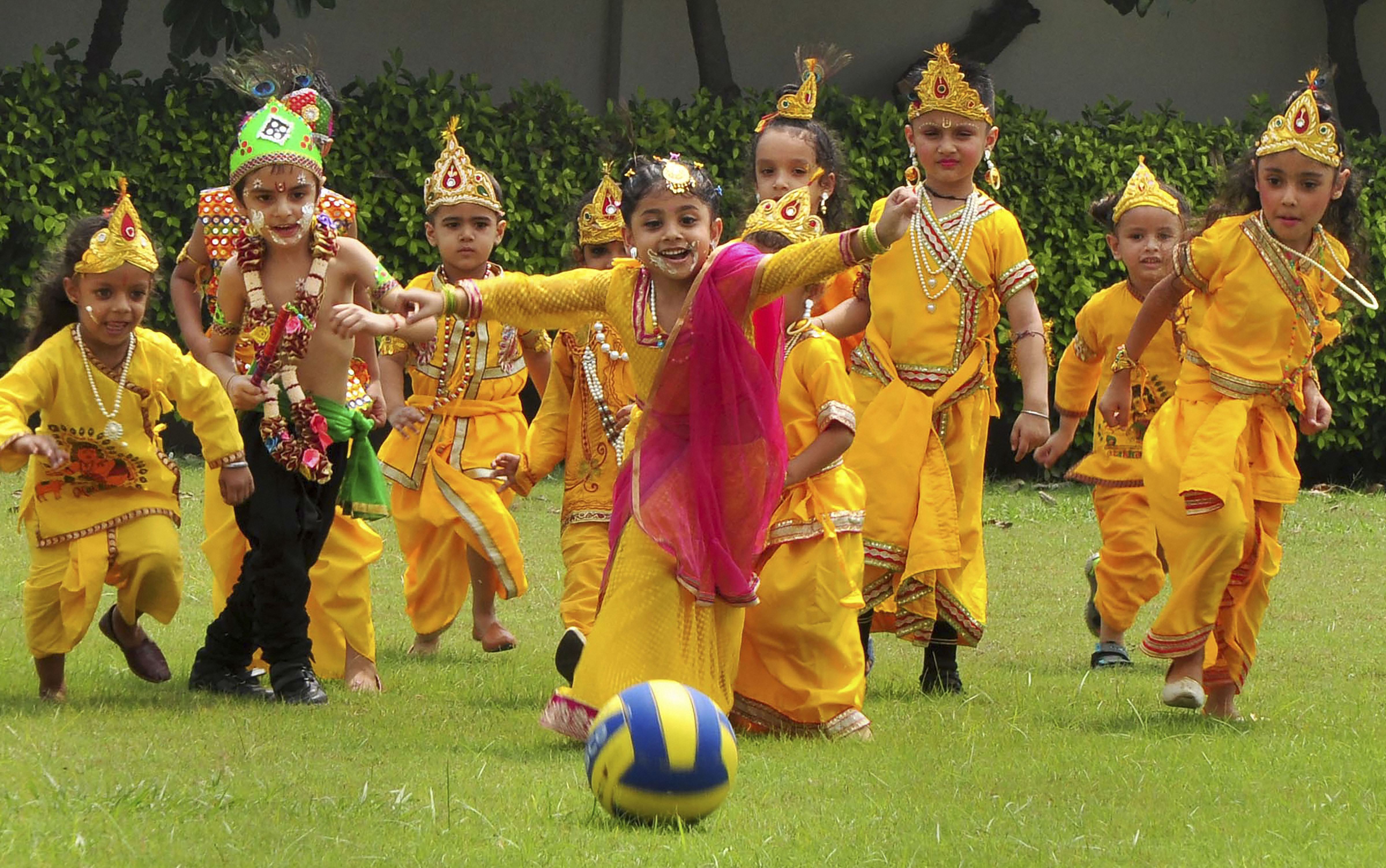 Children dressed up as Lord Krishna play football during 'Janmashtami' celebrations at a school, in Patiala - PTI