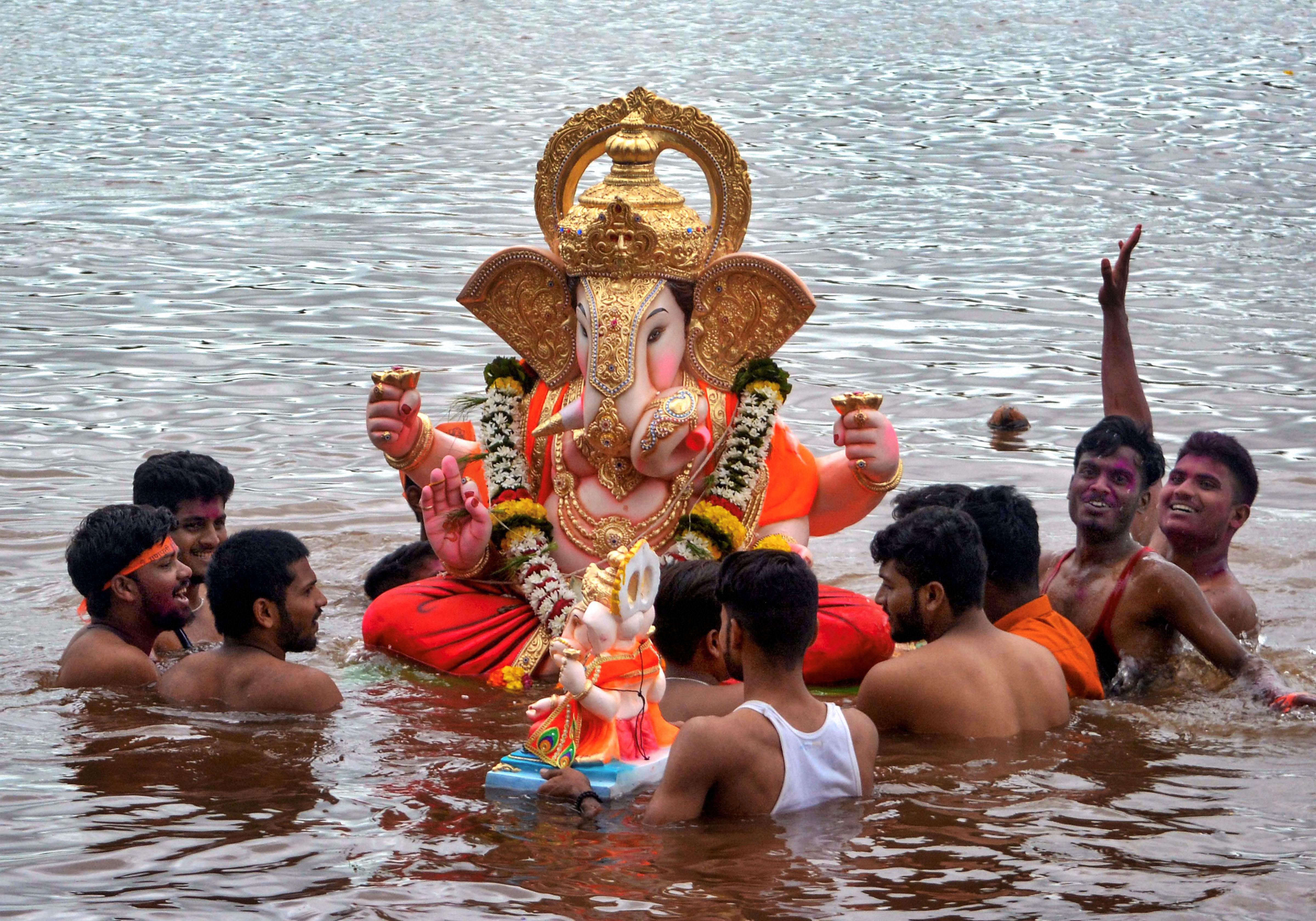 Devotees immerse a Lord Ganesha idol in Krishna River during Ganesh festival celebrations - PTI