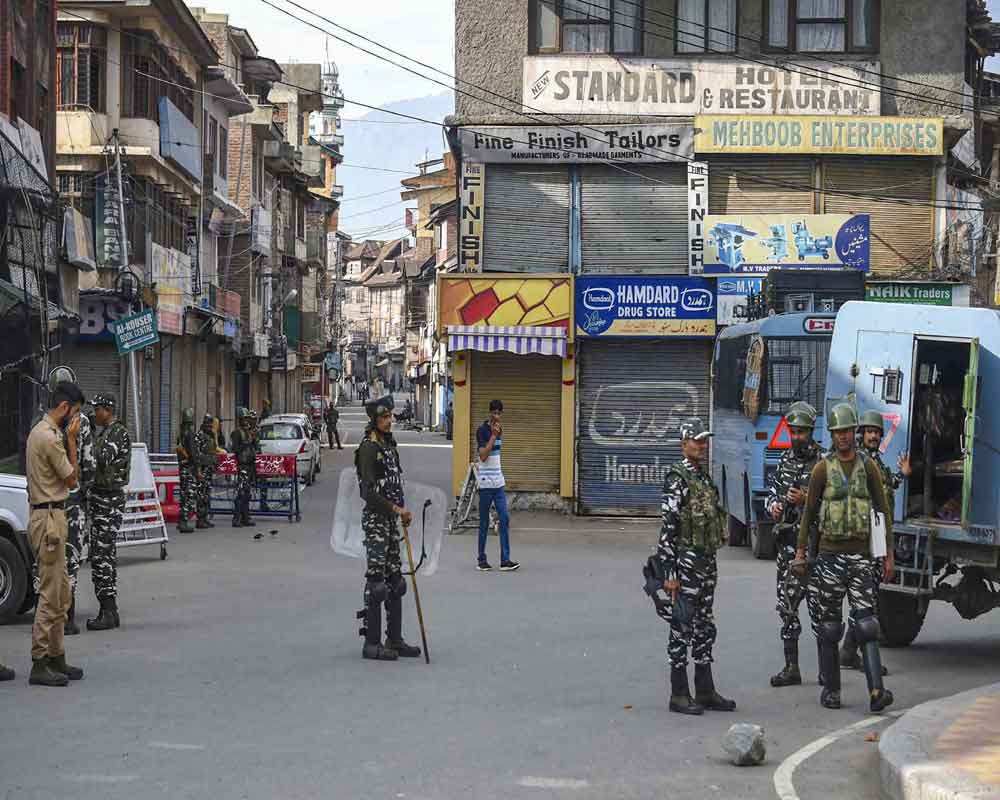 Security personnel stand guard during restrictions following the abrogation of the provisions of Article 370, in Srinagar, Friday, Aug 16, 2019. Most phone lines in the Valley will be gradually restored over the weekend and schools will reopen area-wise next week, a top Jammu and Kashmir official said on Friday while announcing the easing of restrictions in a phased and 'orderly way' - PTI