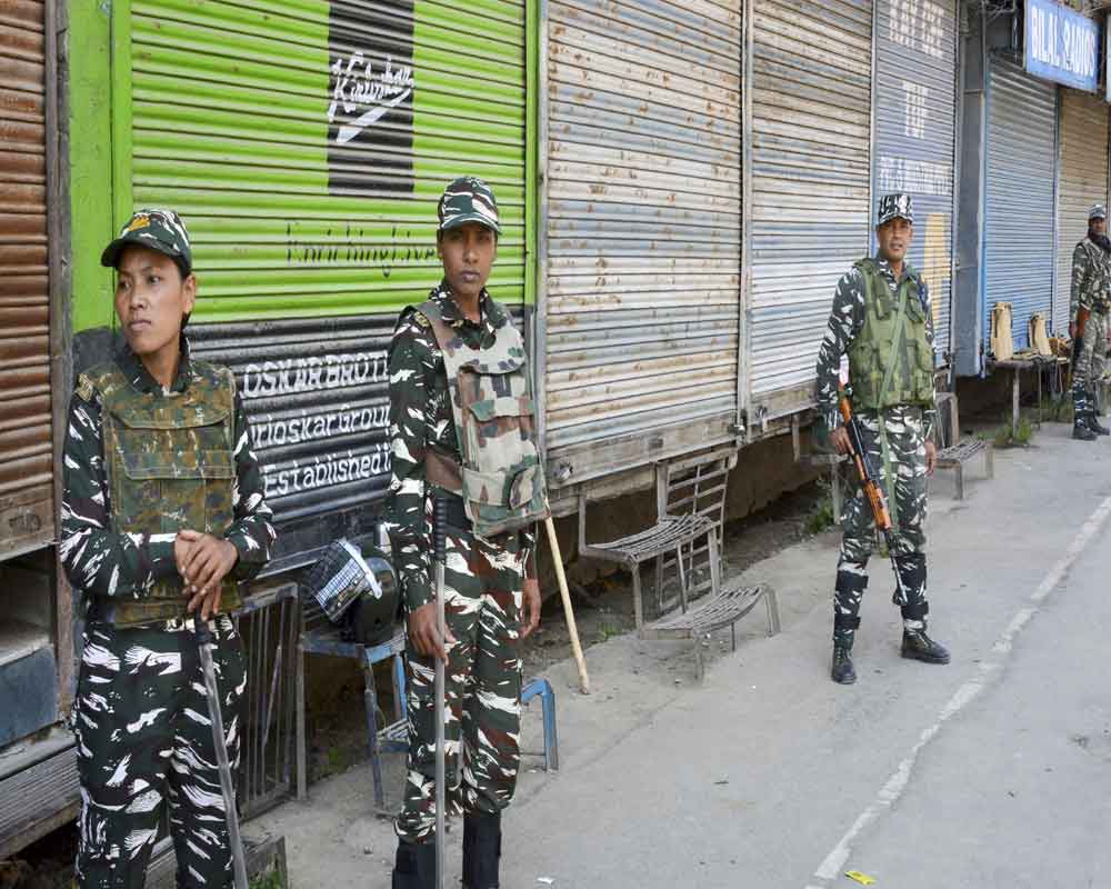 Security personnel stand guard at a closed market during restrictions to maintain law and order, in Srinagar - PTI