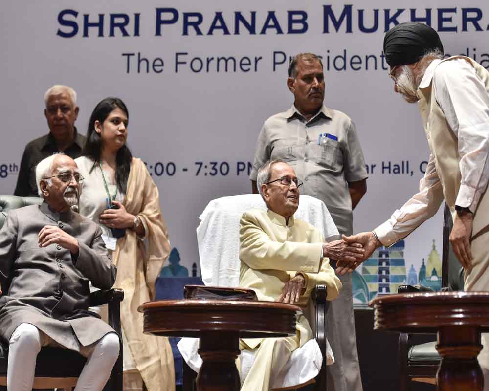 Former President Pranab Mukherjee is greeted by senior advocate and Rajya Sabha member K T S Tulsi as former Vice President Mohammad Hamid Ansari looks on during an event at Mavalankar Hall - PTI